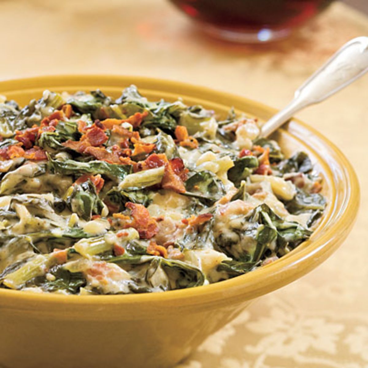 Healthy creamed collard greens in a yellow bowl.