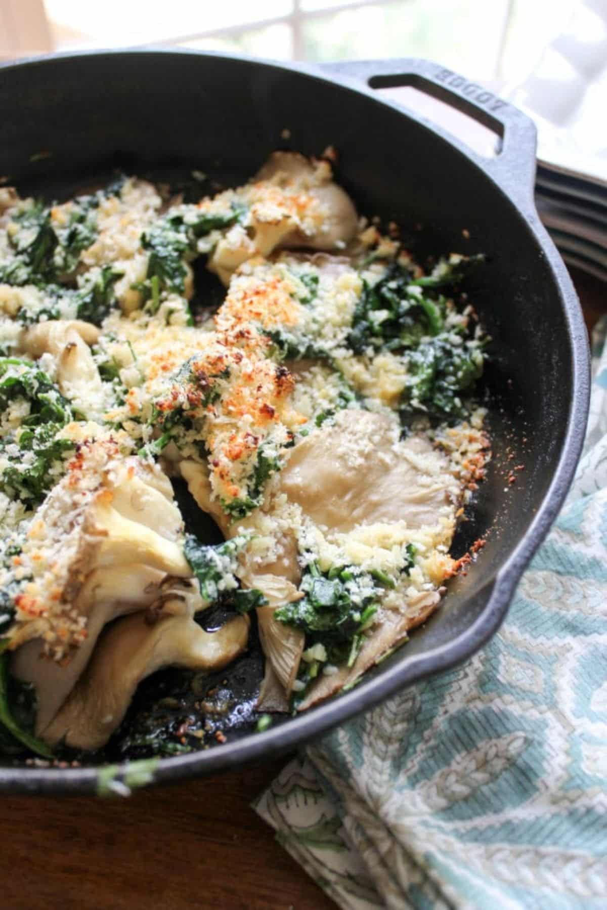 Mouth-watering oyster mushrooms rockefeller in a skillet.