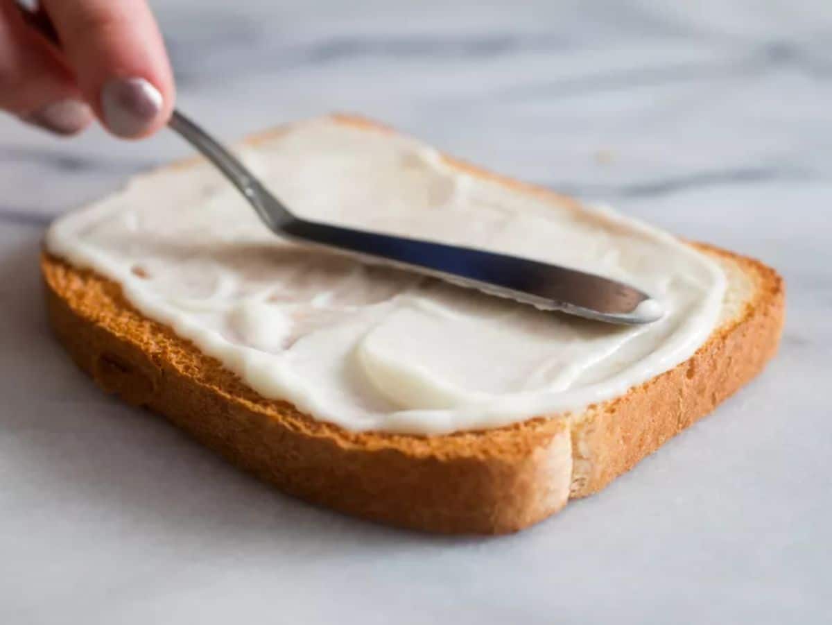 Creamy egg white mayonnaise spread on a piece of bread.
