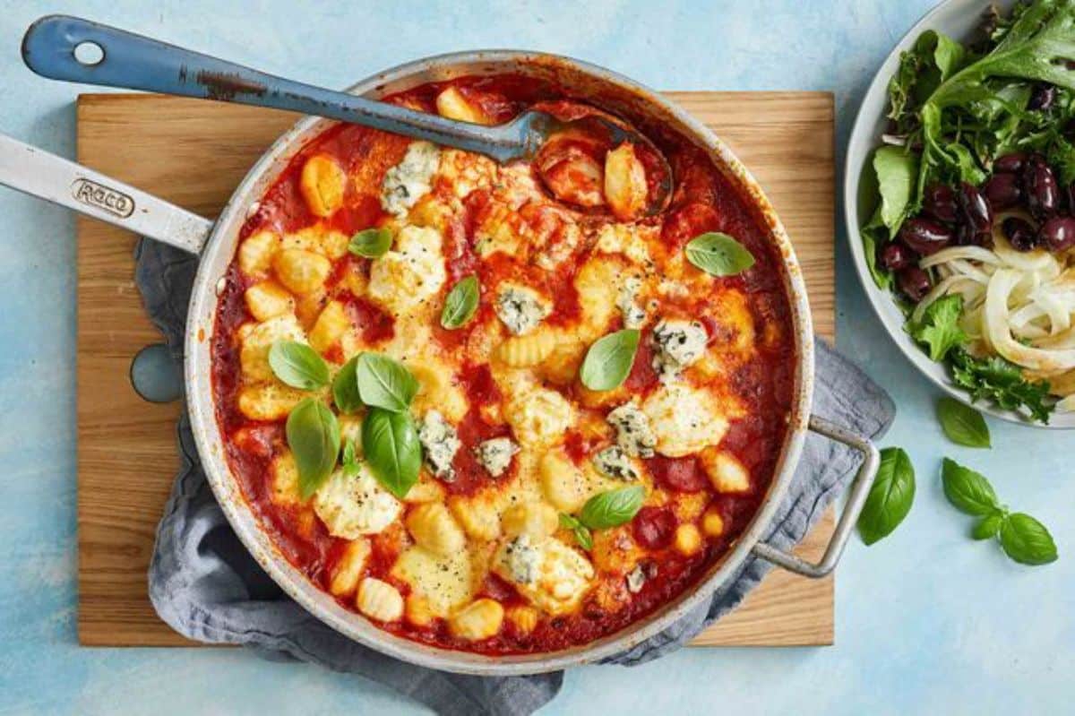 Juicy four-cheese gnocchi al forno in a skillet.