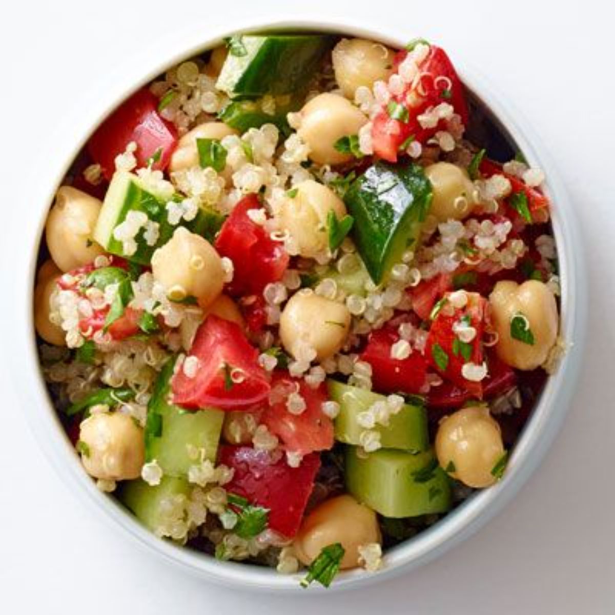 Healthy quinoa tabbouleh salad in a white bowl.