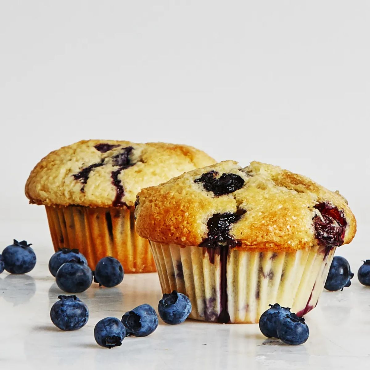 Tasty sour cream classic blueberry muffins on a table.