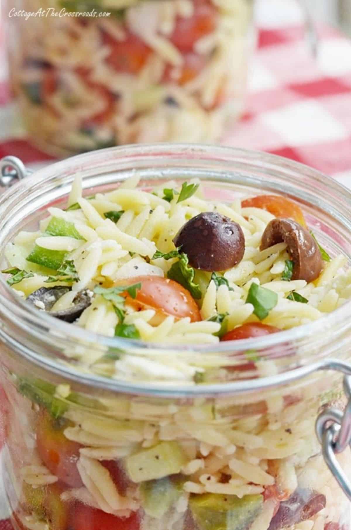 Healthy lemony garden fresh orzo salad in a glass jar.