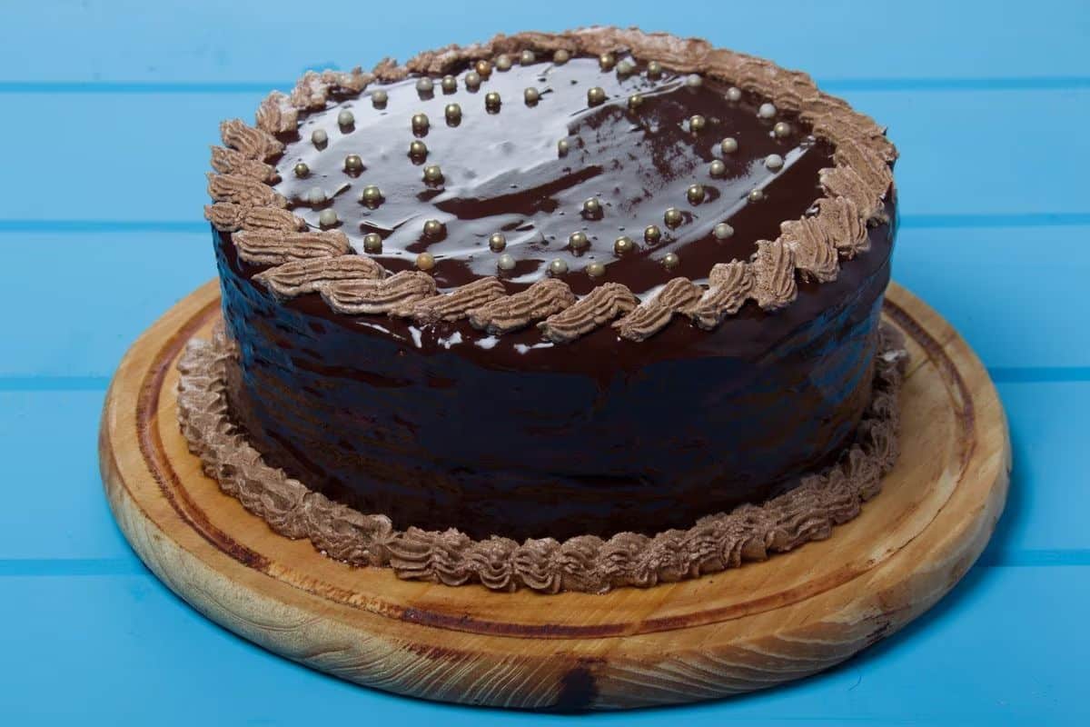 Mouth-watering doberge cake on a wooden tray.