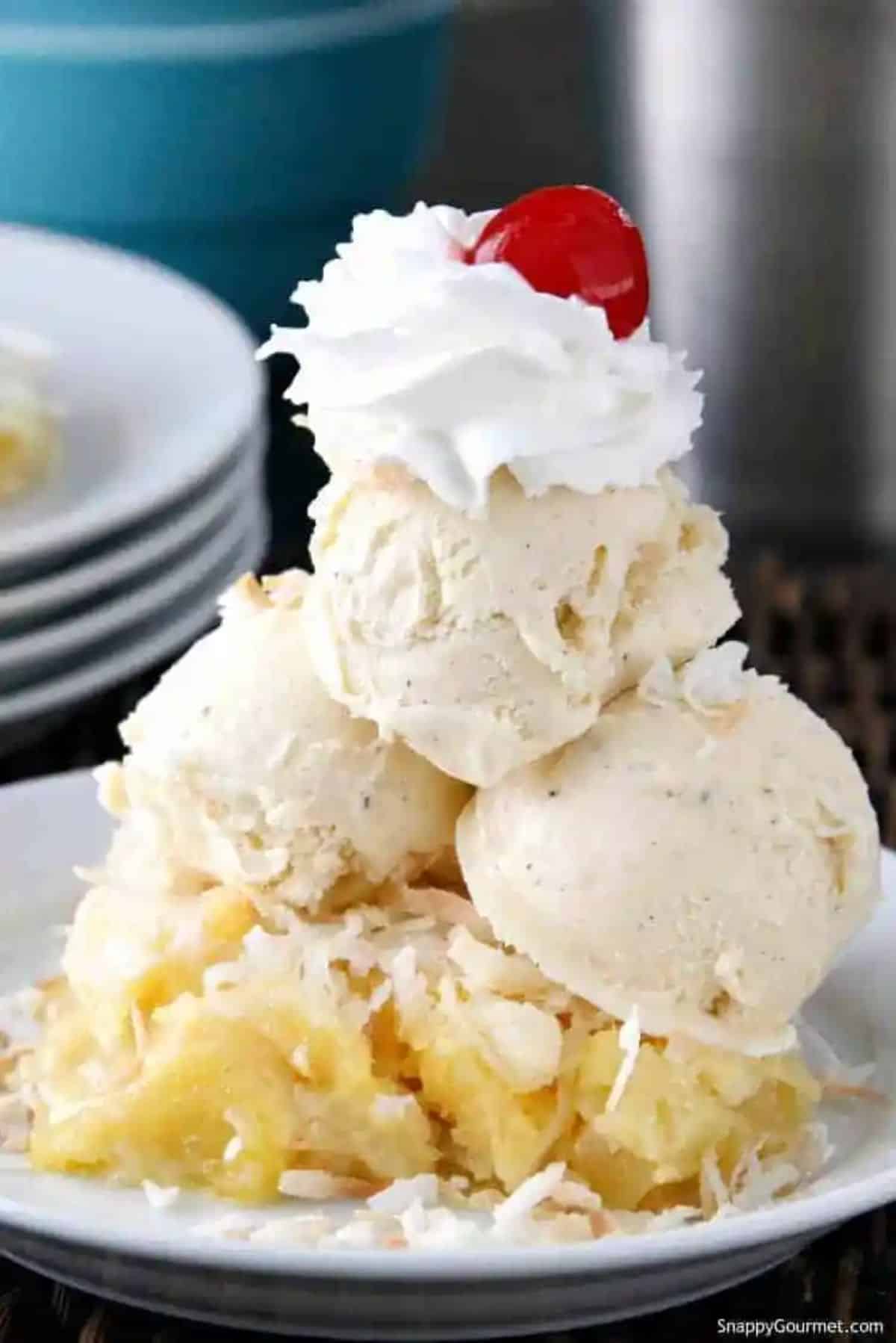 Delicious tropical piña colada dump cake garnished with ice cream on a white plate.