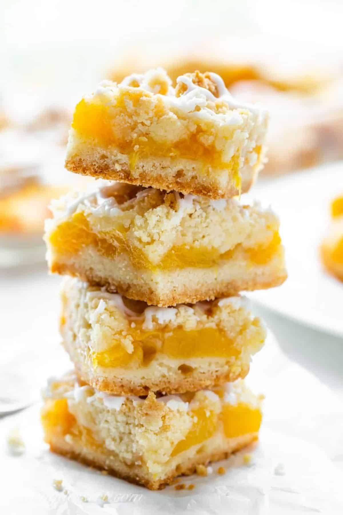 A pile of delicious fresh peach crumb bars on a plate.
