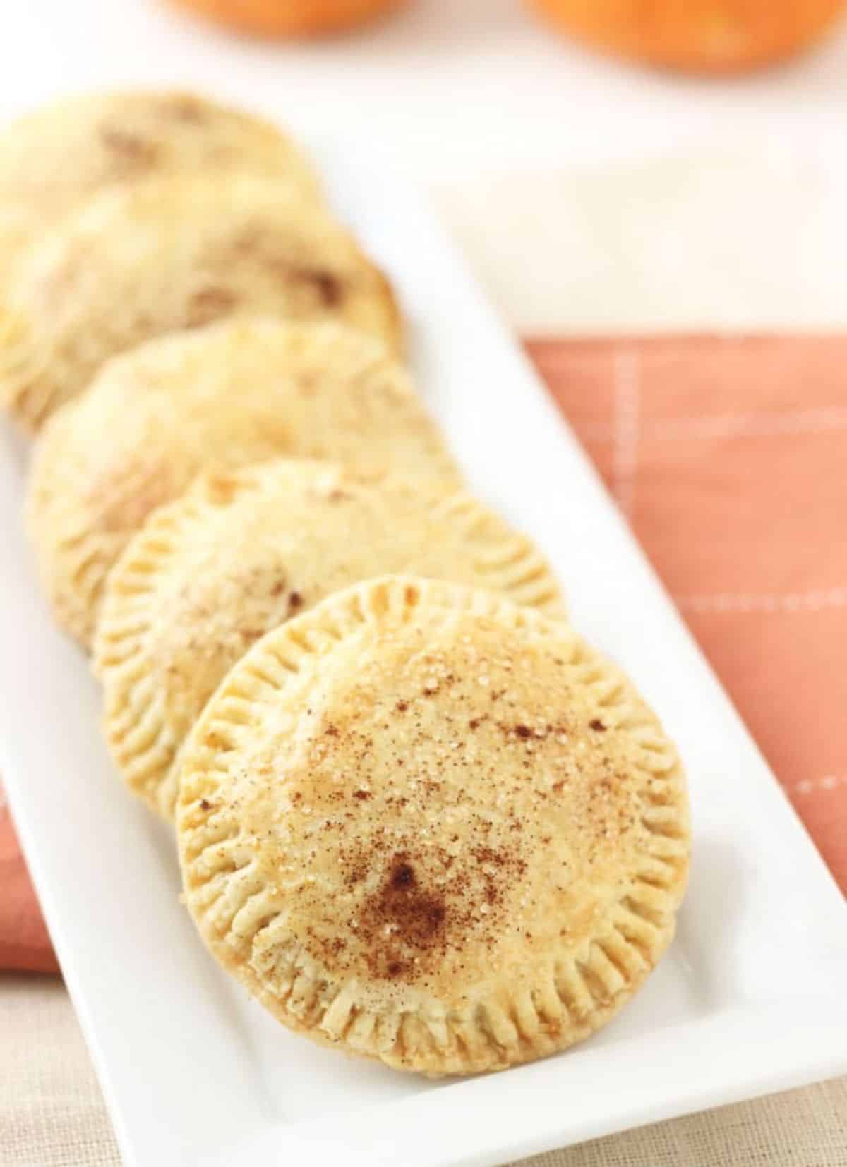 Crunchy pumpkin butter hand pies on a white tray.