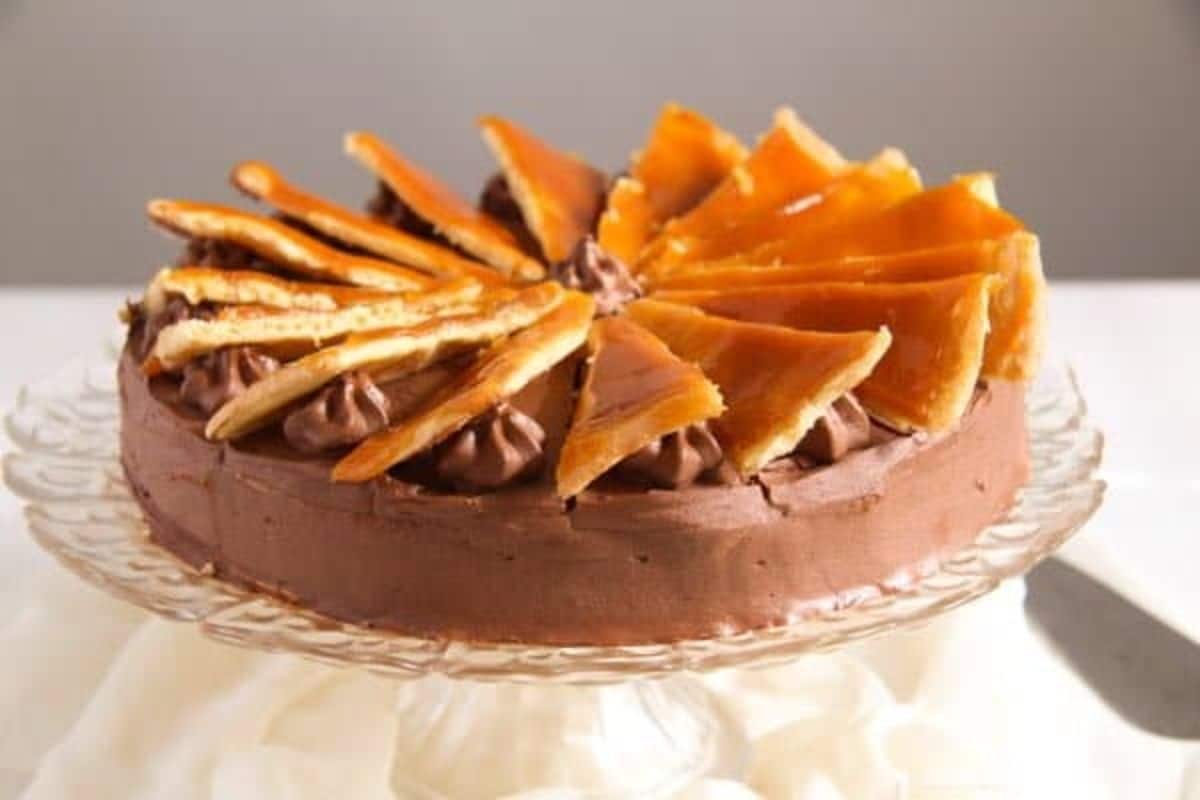 Flavorful dobos torte on a glass cake tray.