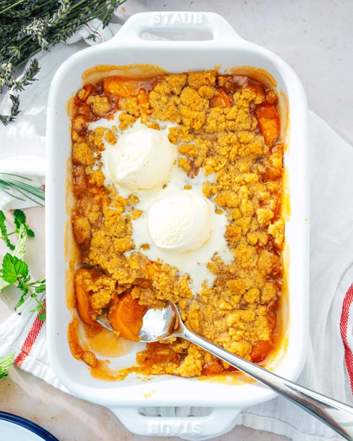 Crispy peach crumble in a white casserole.