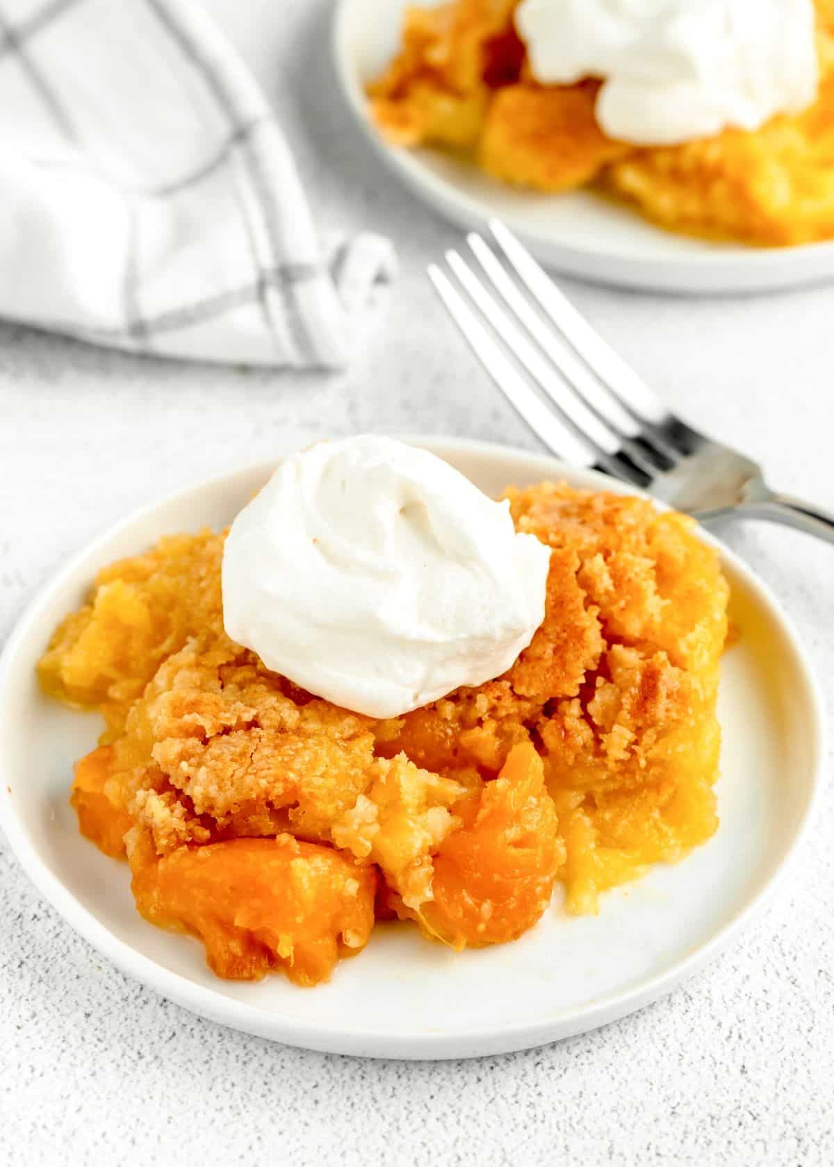 A piece of mouth-watering peach dump cake on a white plate.