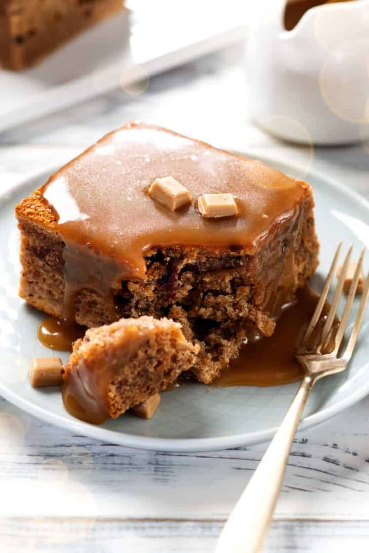Mouth-watering sticky toffee pudding on a plate with a fork.