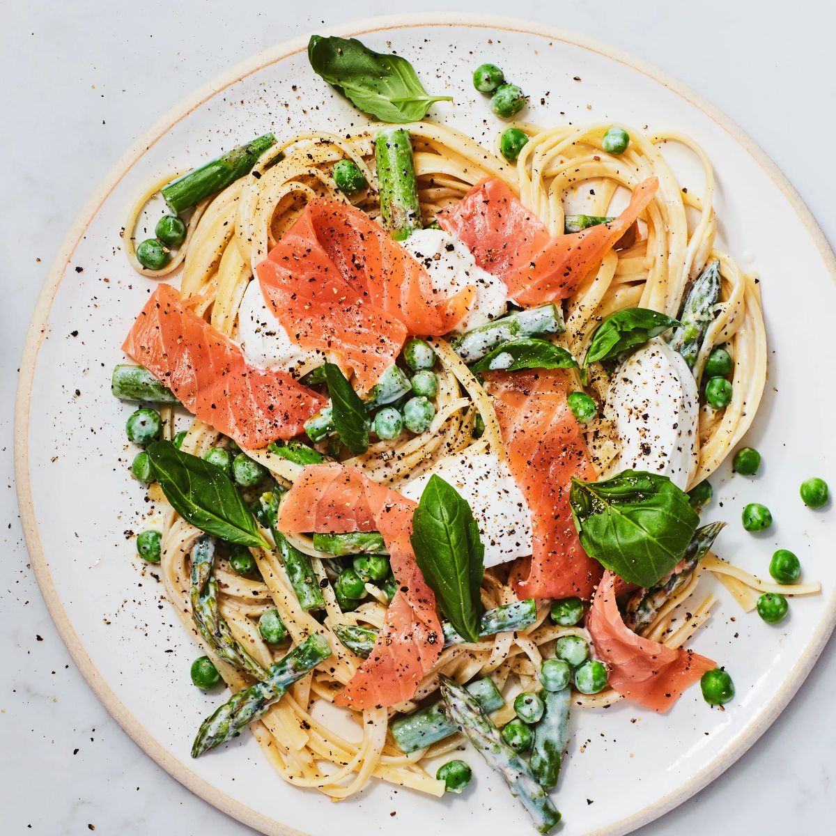 Healthy one-pot spring pasta with cooked salmon on a plate.