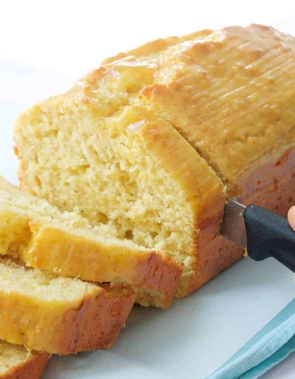 Flavorful yogurt cake sliced by a knife.