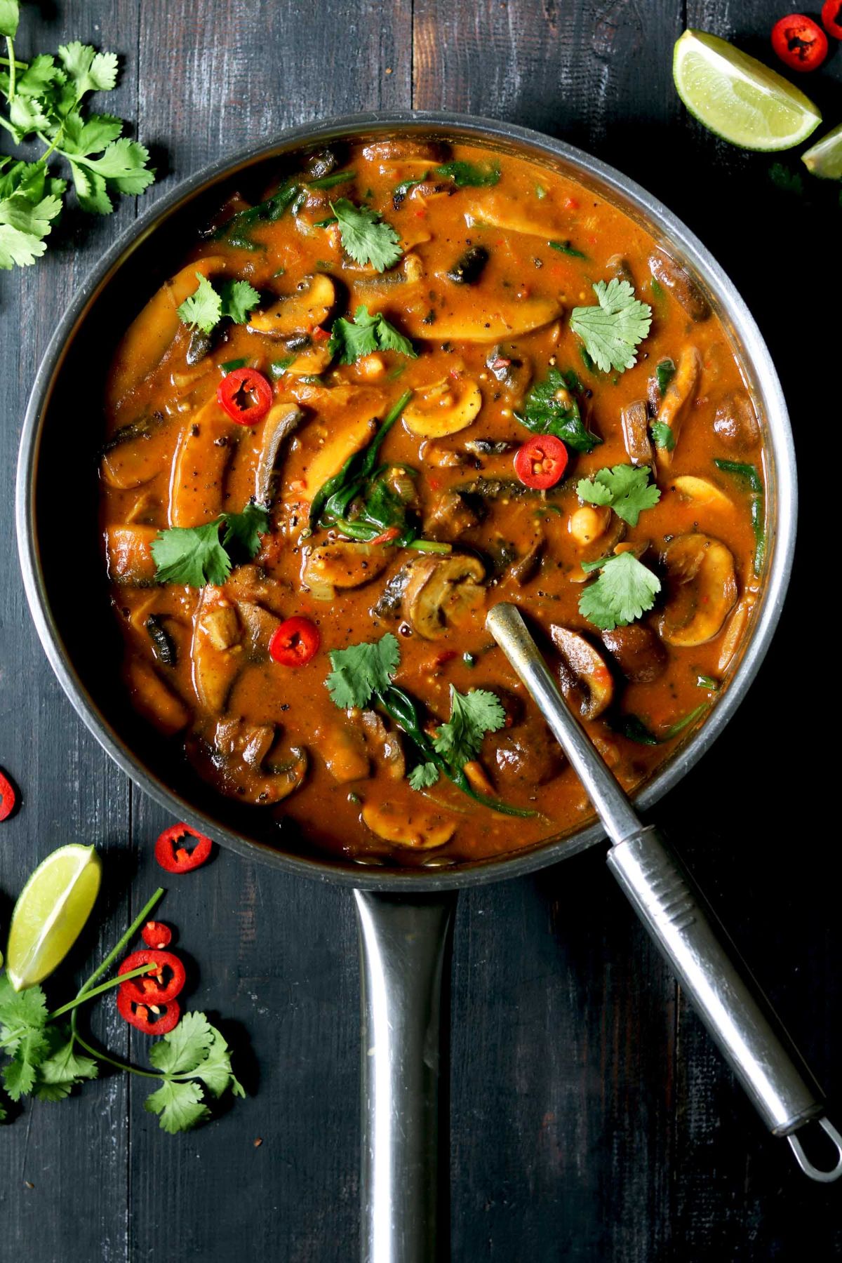 Juicy mushroom curry with spinach and chickpeas in a skillet.