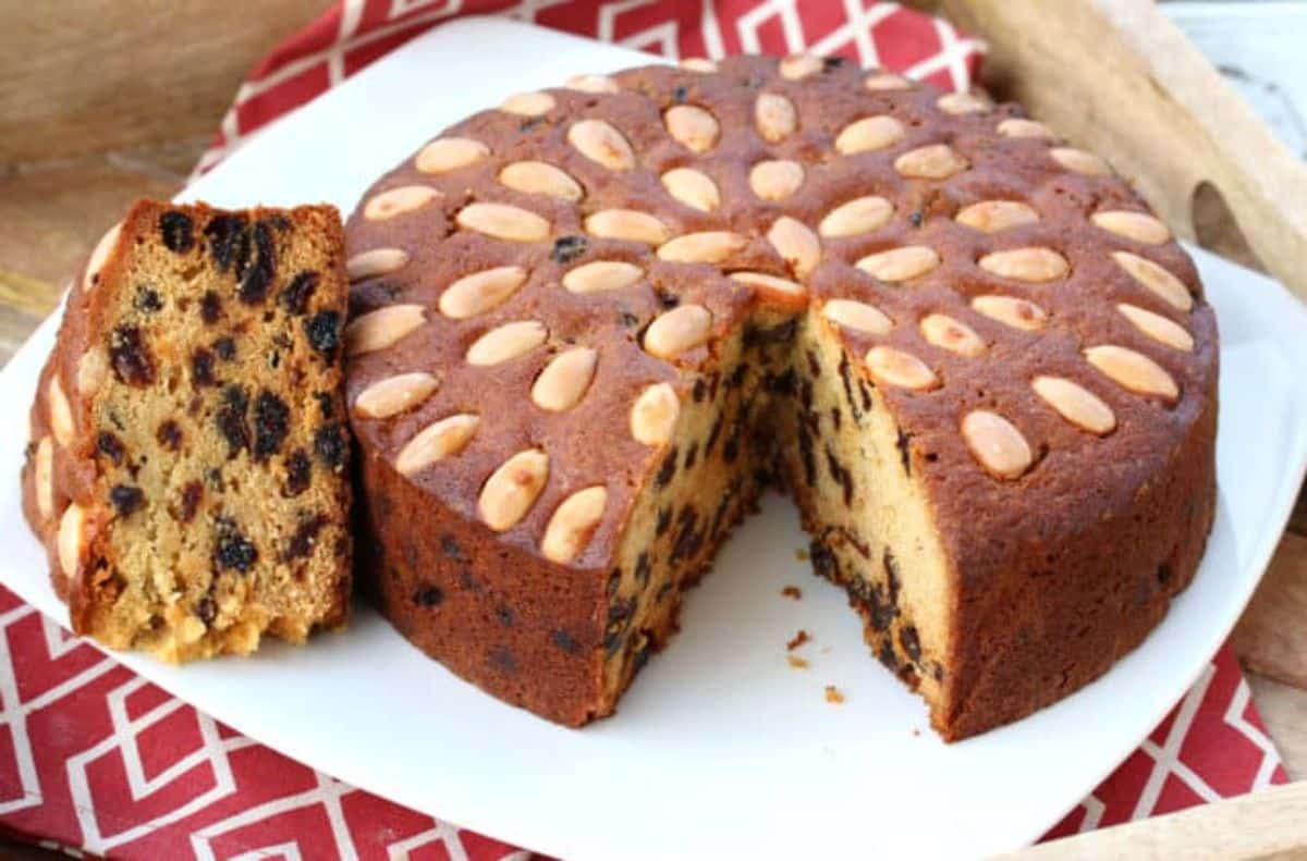 Scrumptious dundee cake on a white tray.