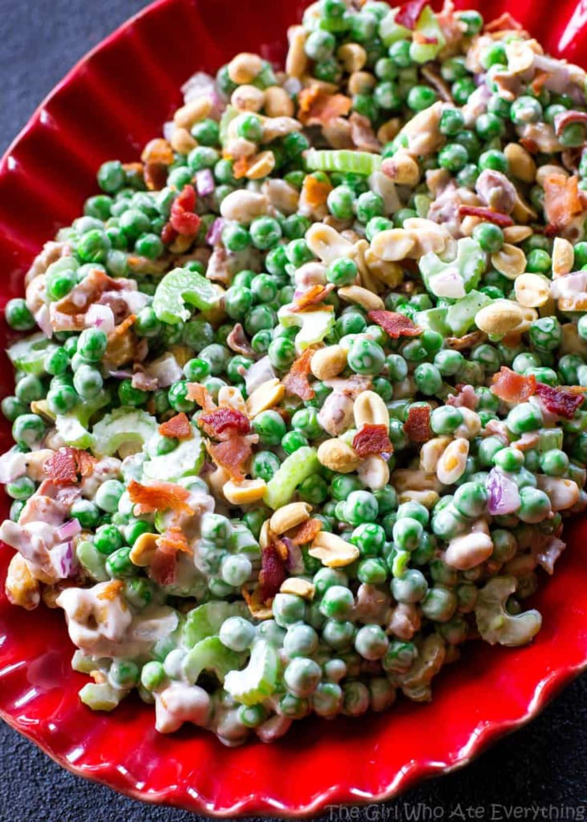 Healthy crunchy pea salad in a red bowl.