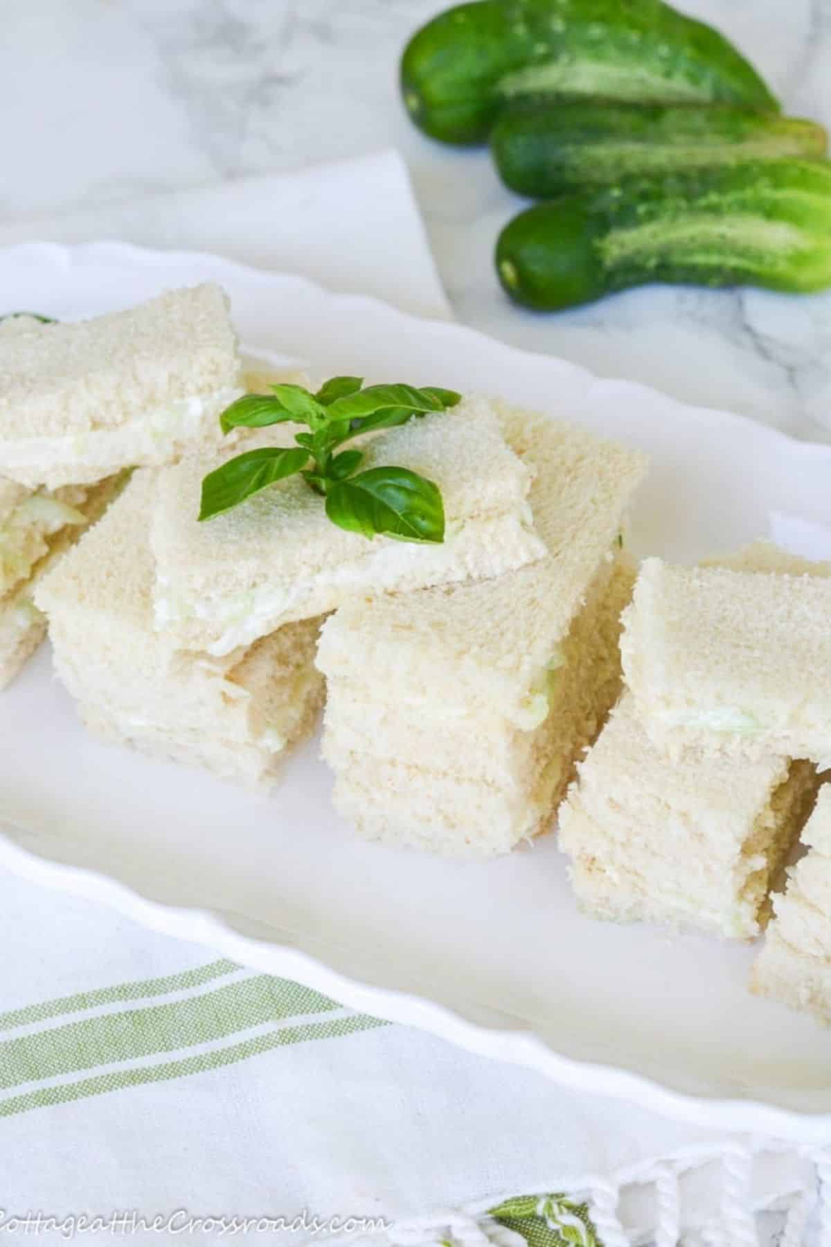 Scrumptious cucumber sandwich spread on a white tray.