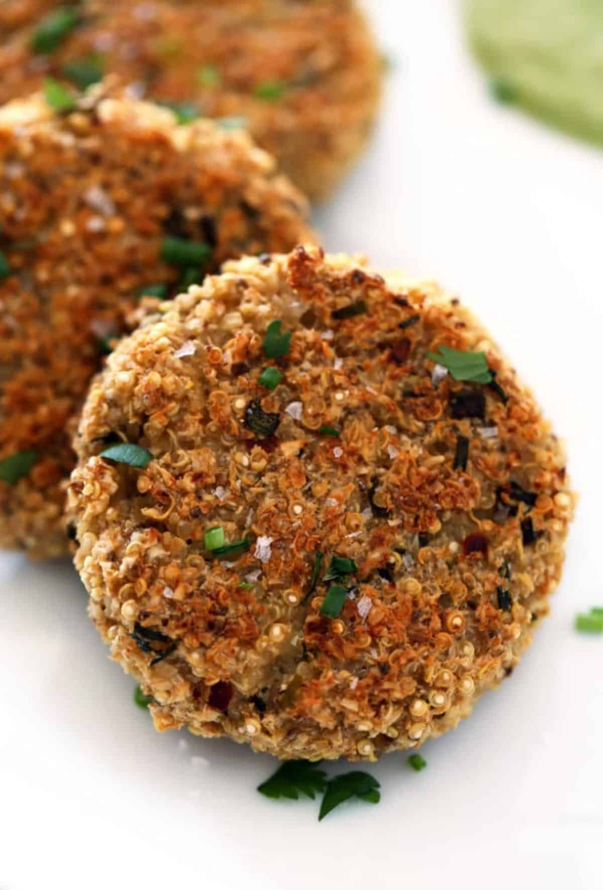 Scrumptious quinoa cauliflower cakes with herbed brazil nut cream on a white tray.