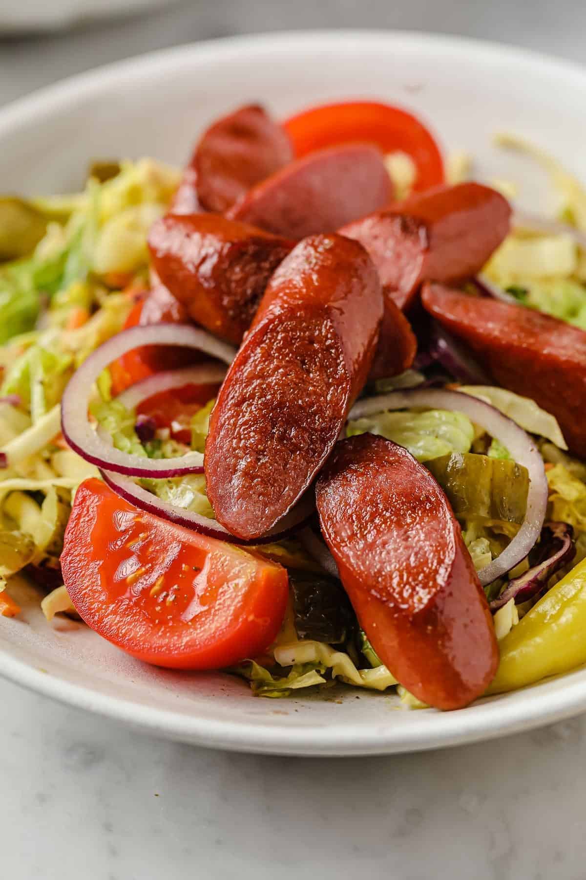 Delicious chicago dog salad in a white bowl.