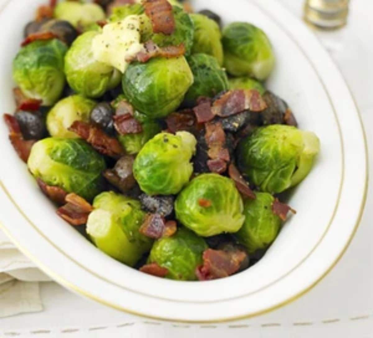 Healthy brussels sprouts with water chestnuts in a white bowl.