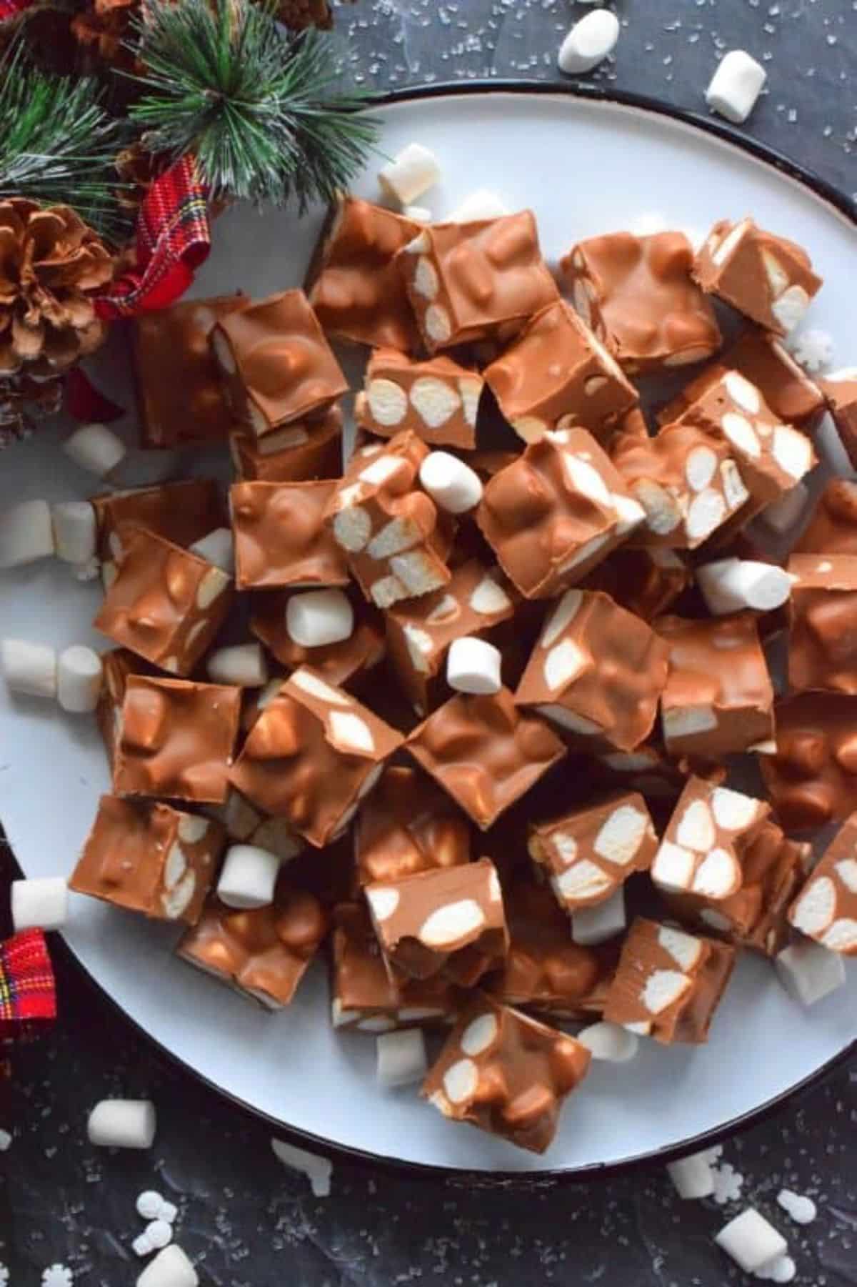 A pile of no bake chocolate marshmallow squares on a tray.