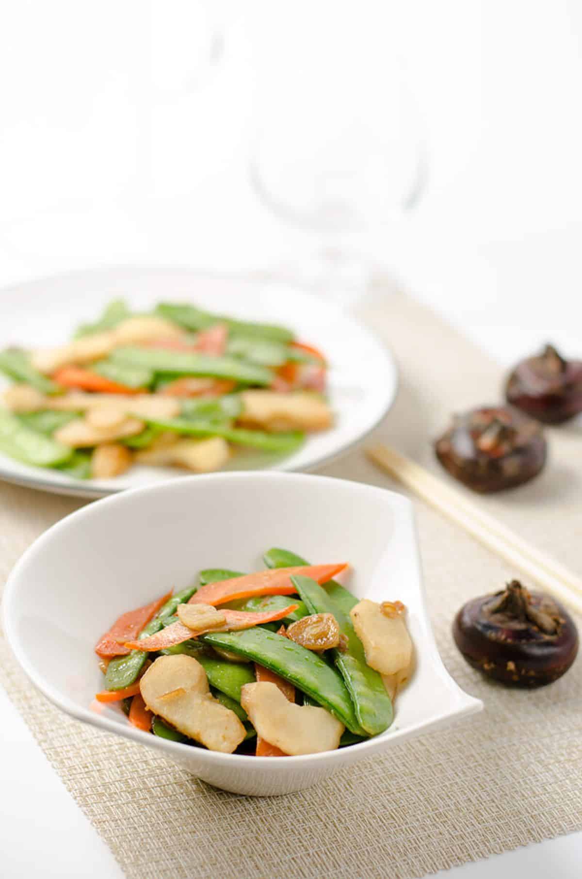 Healthy stir-fried snow peas in a white bowl.