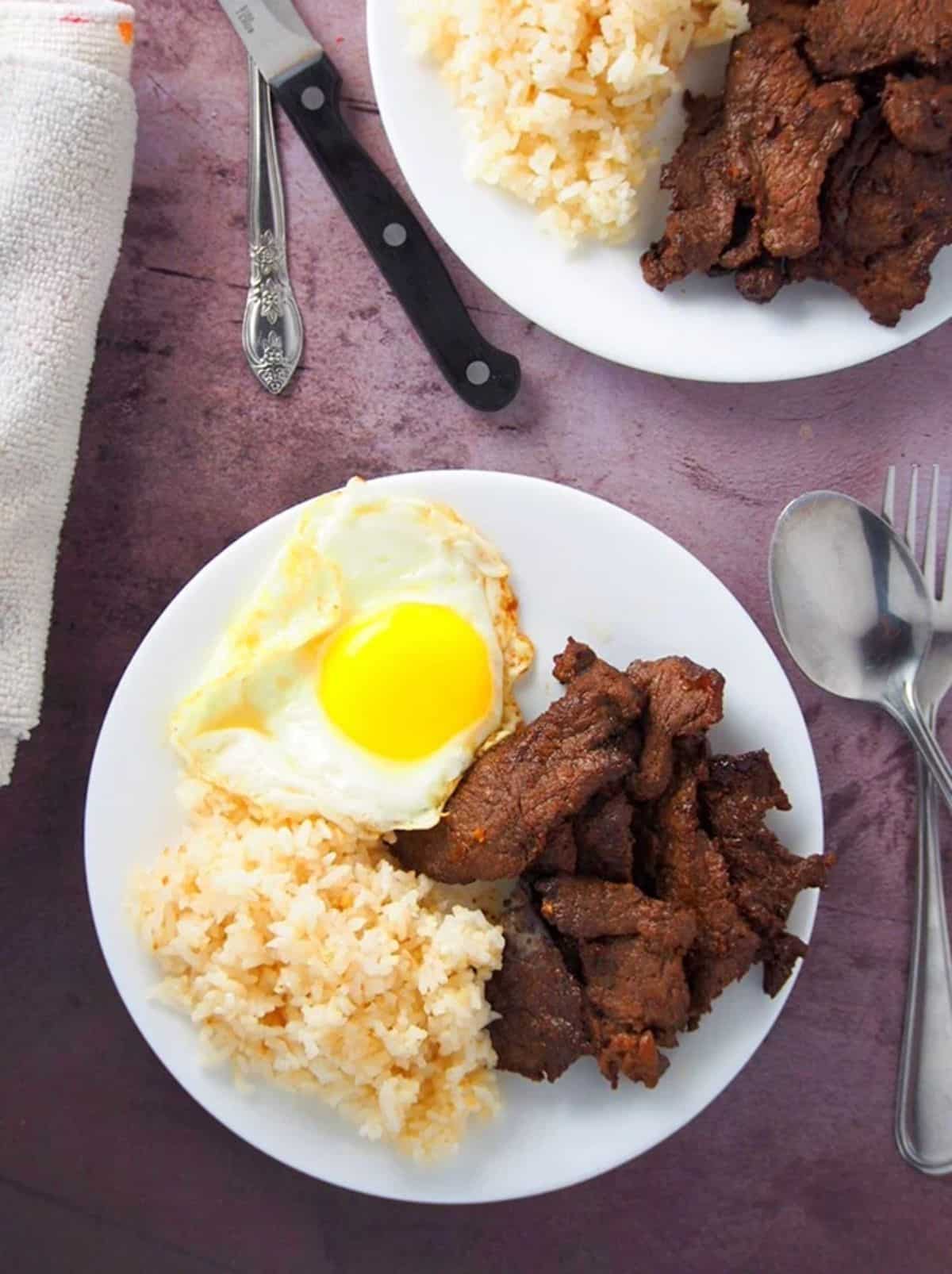 Delicious tapsilog on a white plate.