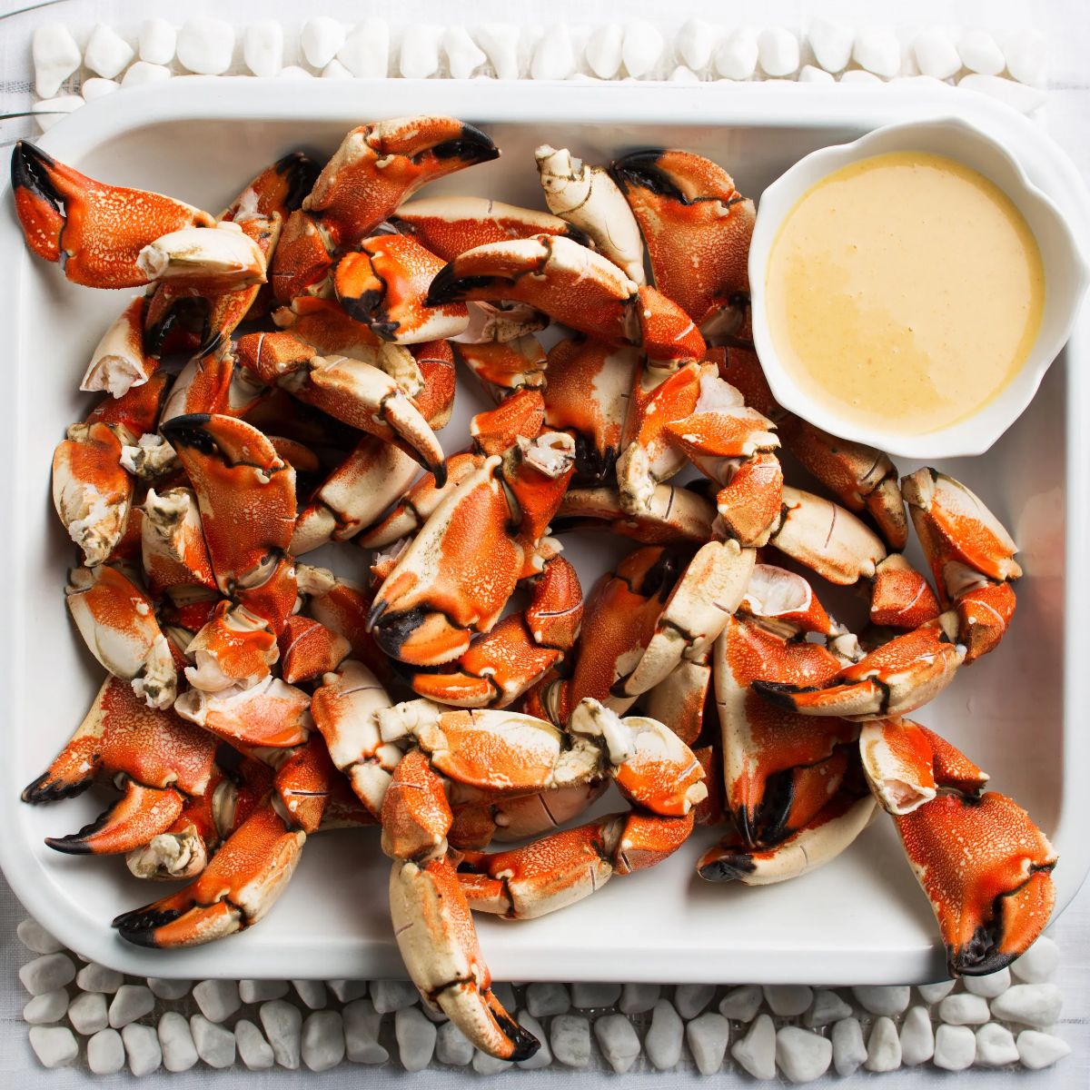 Flavorful stone crab with mustard sauce in a white bowl.