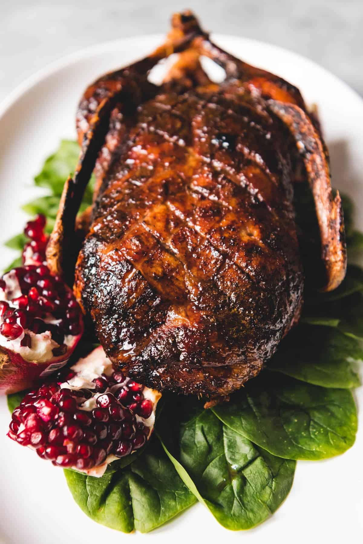 Juicy honey roast duck on a white tray.