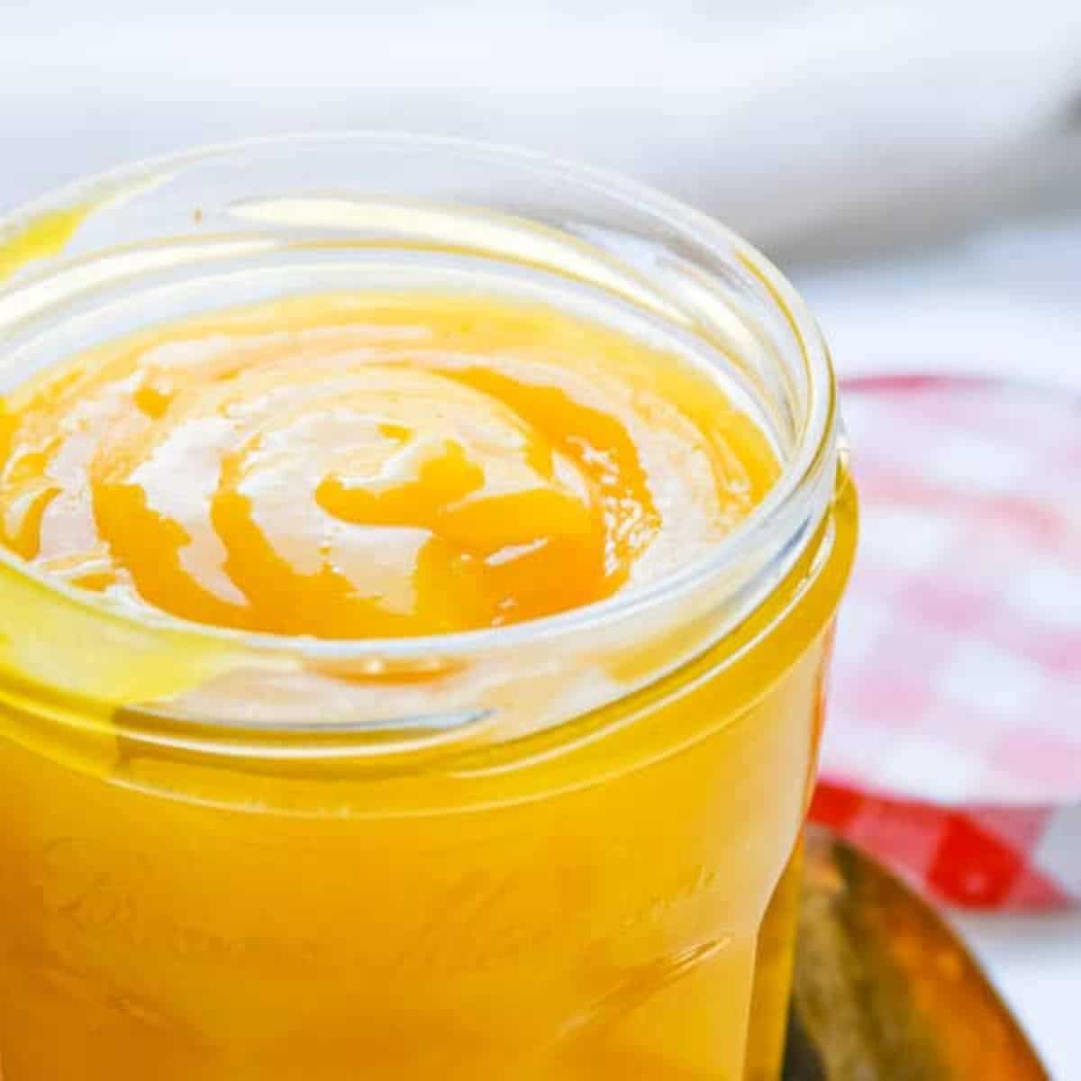Creamy passion fruit curd in a glass jar.