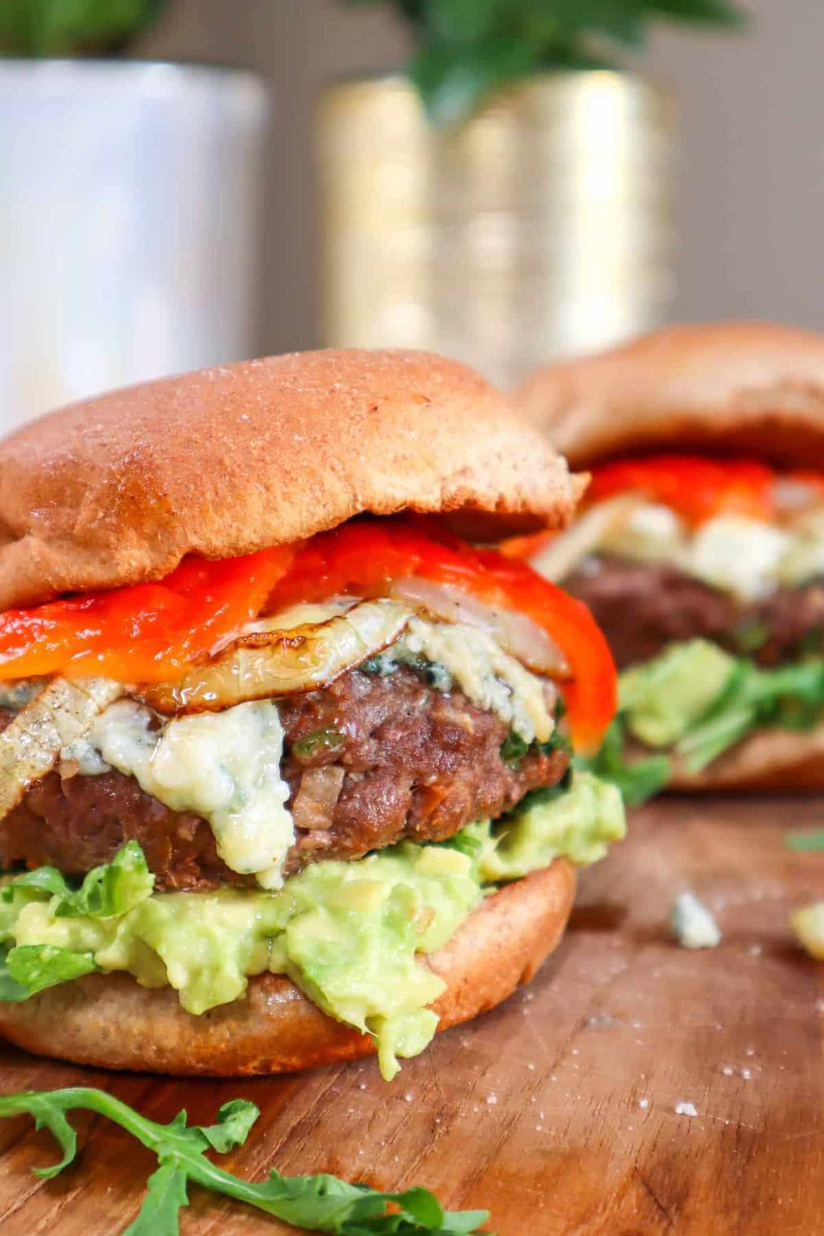 Best juicy and delicious bison burgers on a wooden tray.