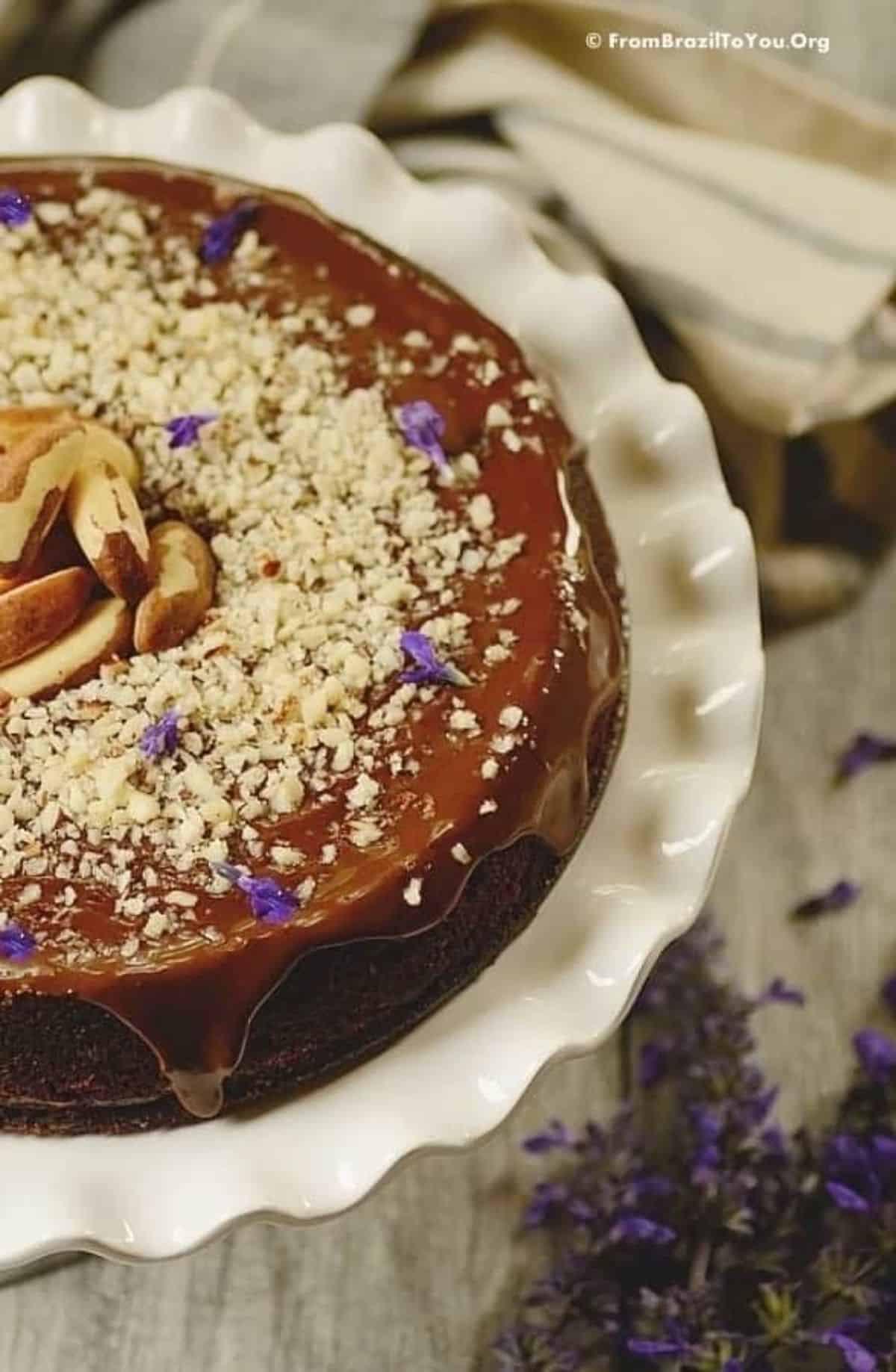 Mouth-watering flourless chocolate nut cake on a cake tray.