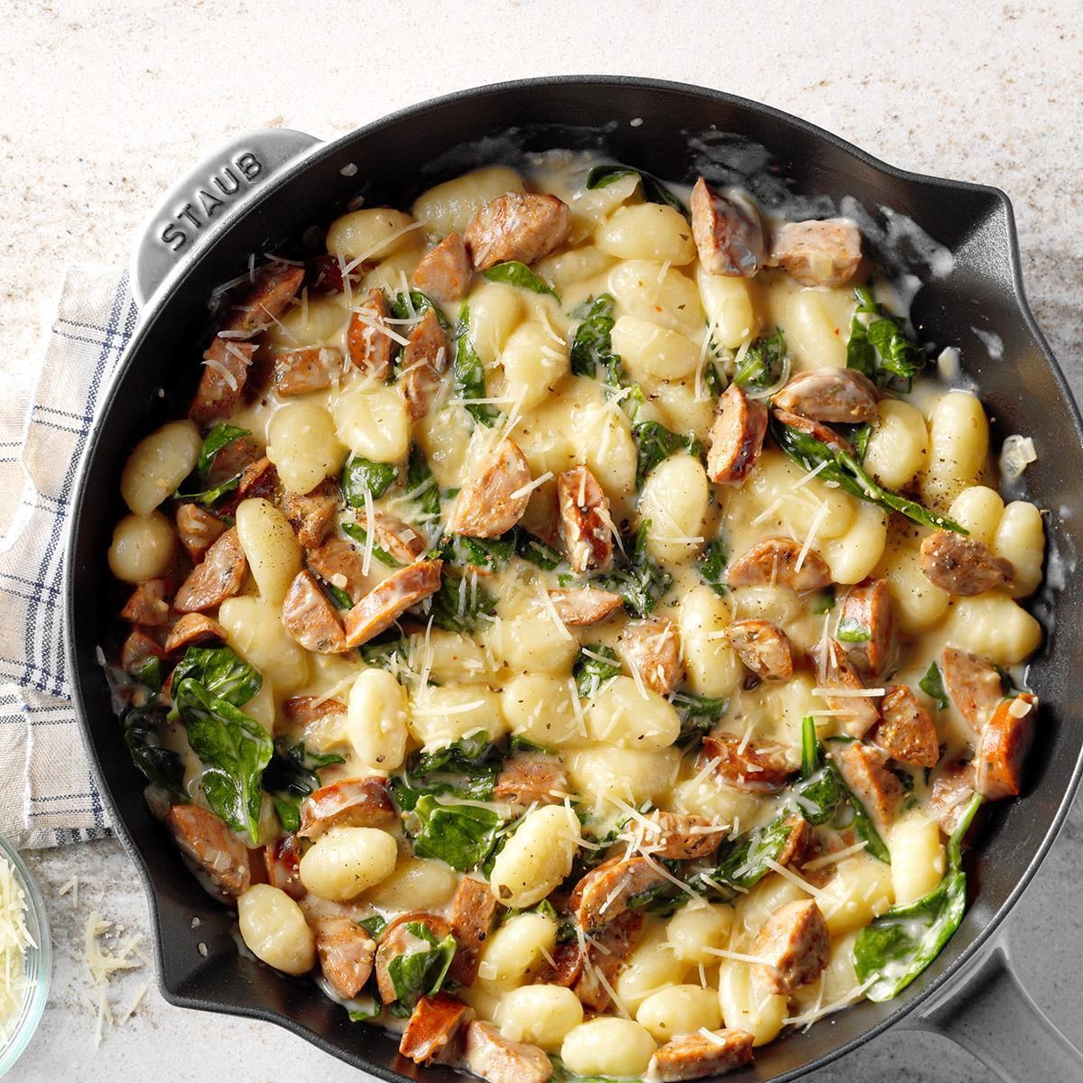 Scrumptious gnocchi with spinach and chicken sausage in a black skillet.