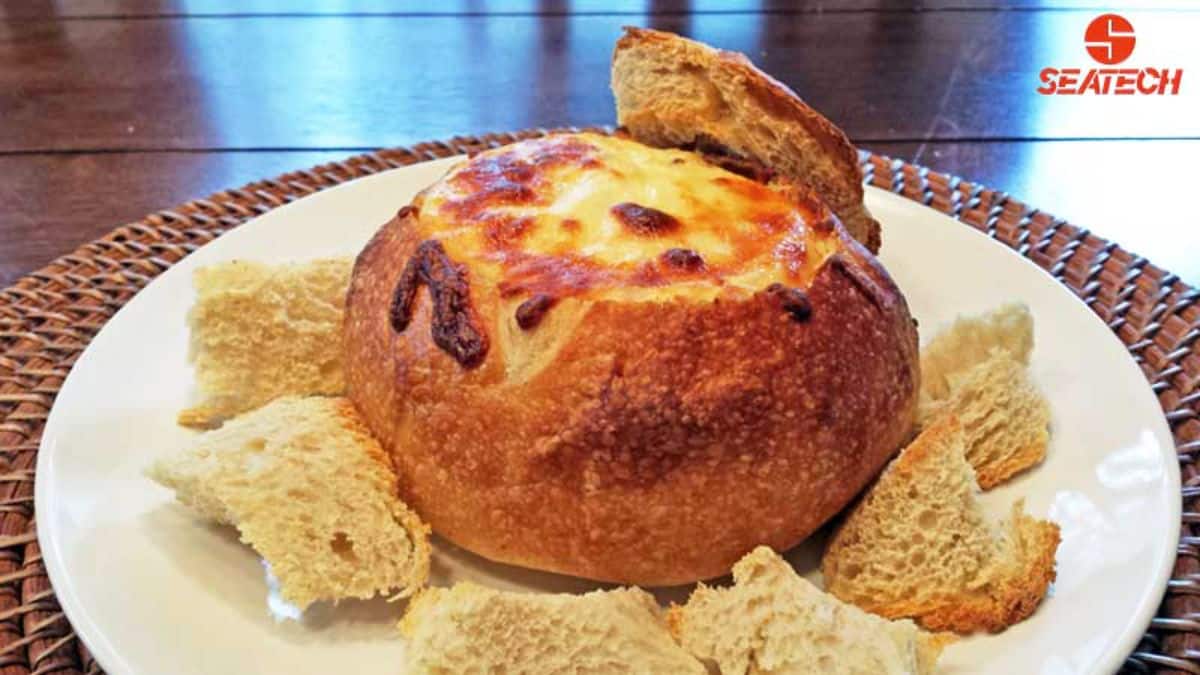 Tastyfeul mini crab dip bread bowls on a white plate.