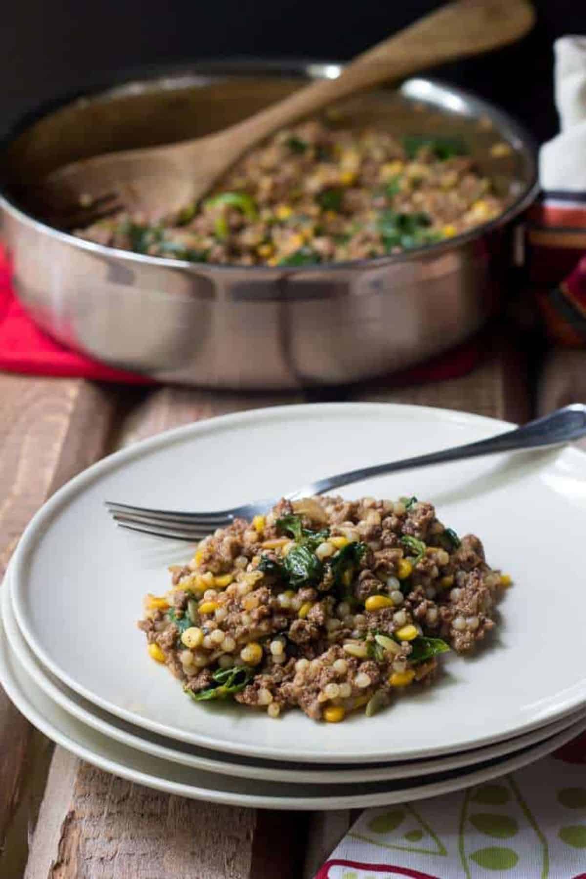 Healthy  bison one-pot dinner on a white plate with a fork.