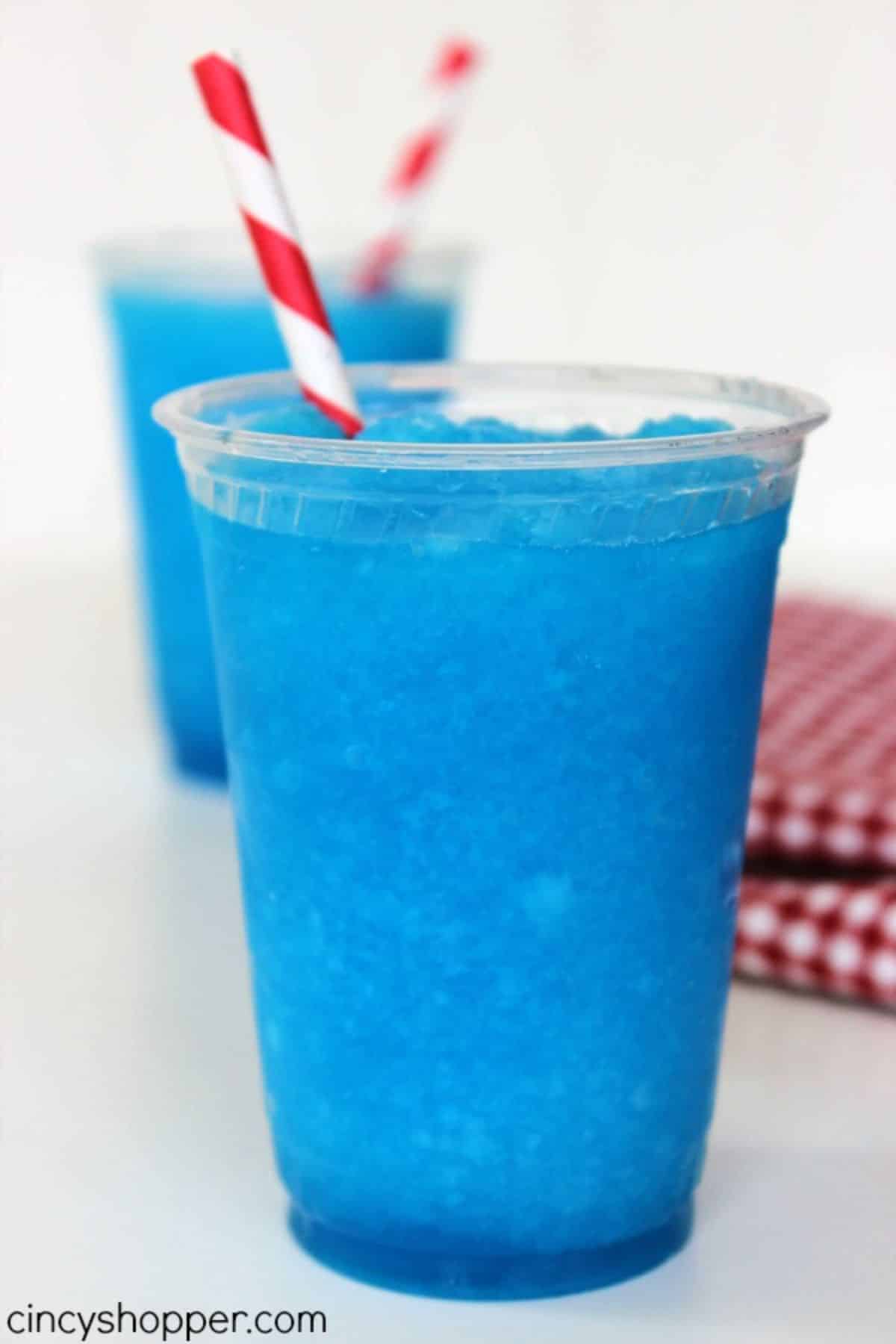 Refreshing raspberry lemonade slurpee in cups with straws.