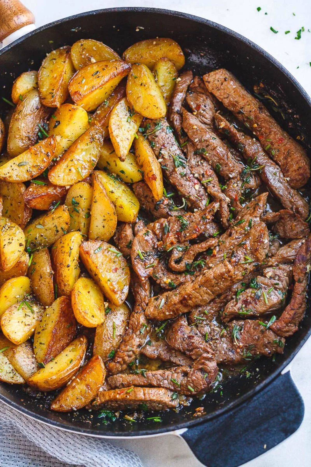 Delicious garlic butter steak and potatoes in a skillet.