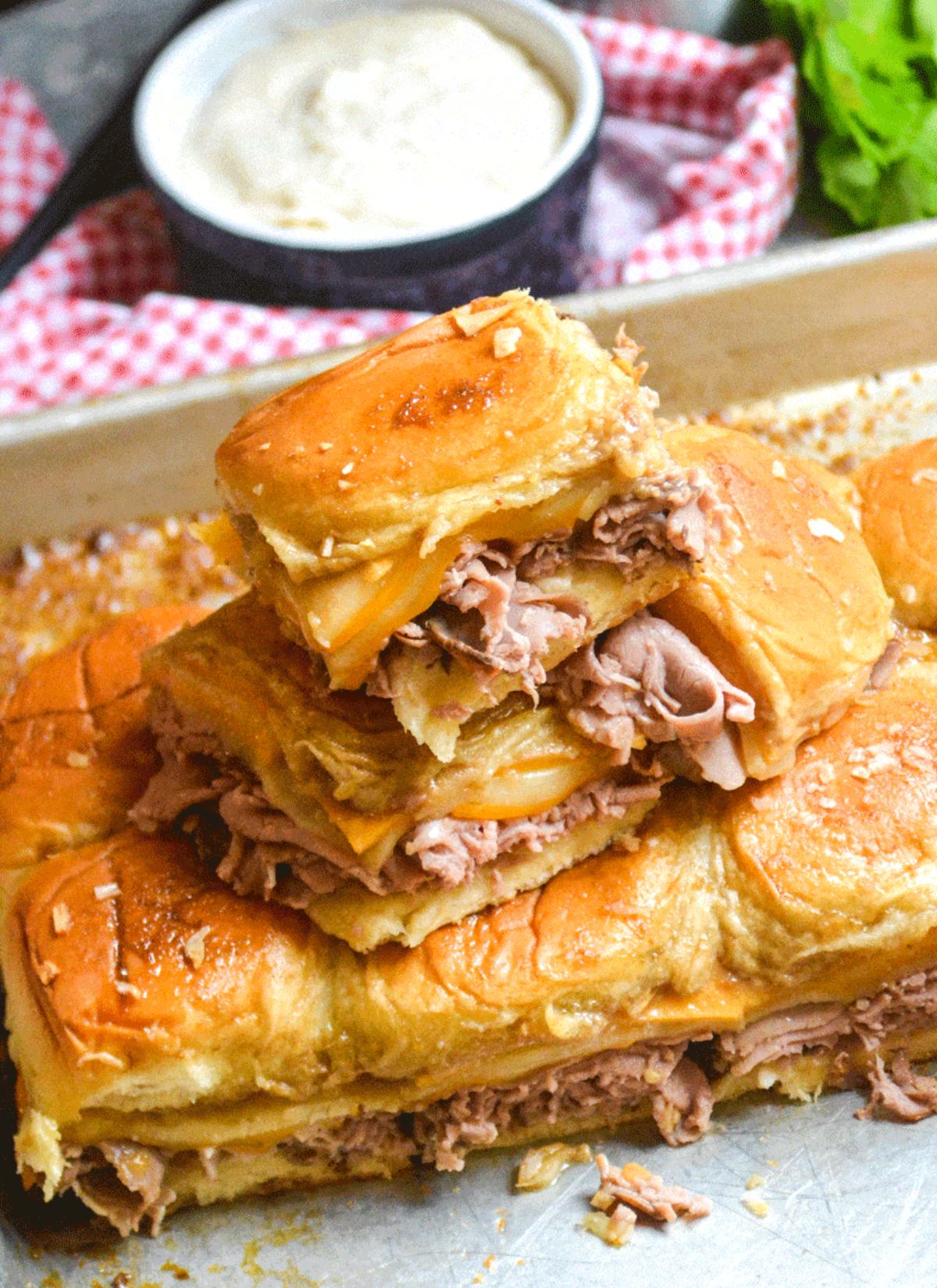 Mouth-watering roast beef and cheddar sliders on a tray.