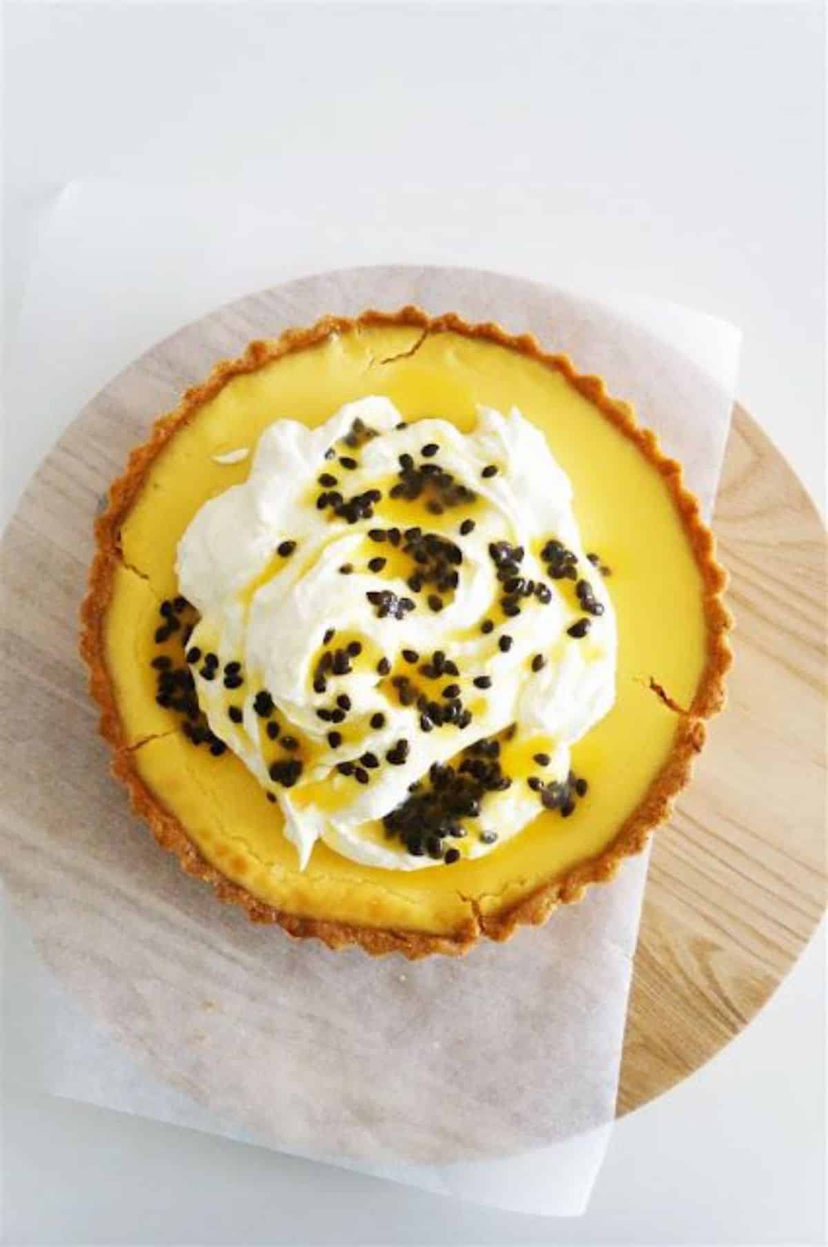 Flavorful passion fruit tart with orange cream on  a wooden tray.