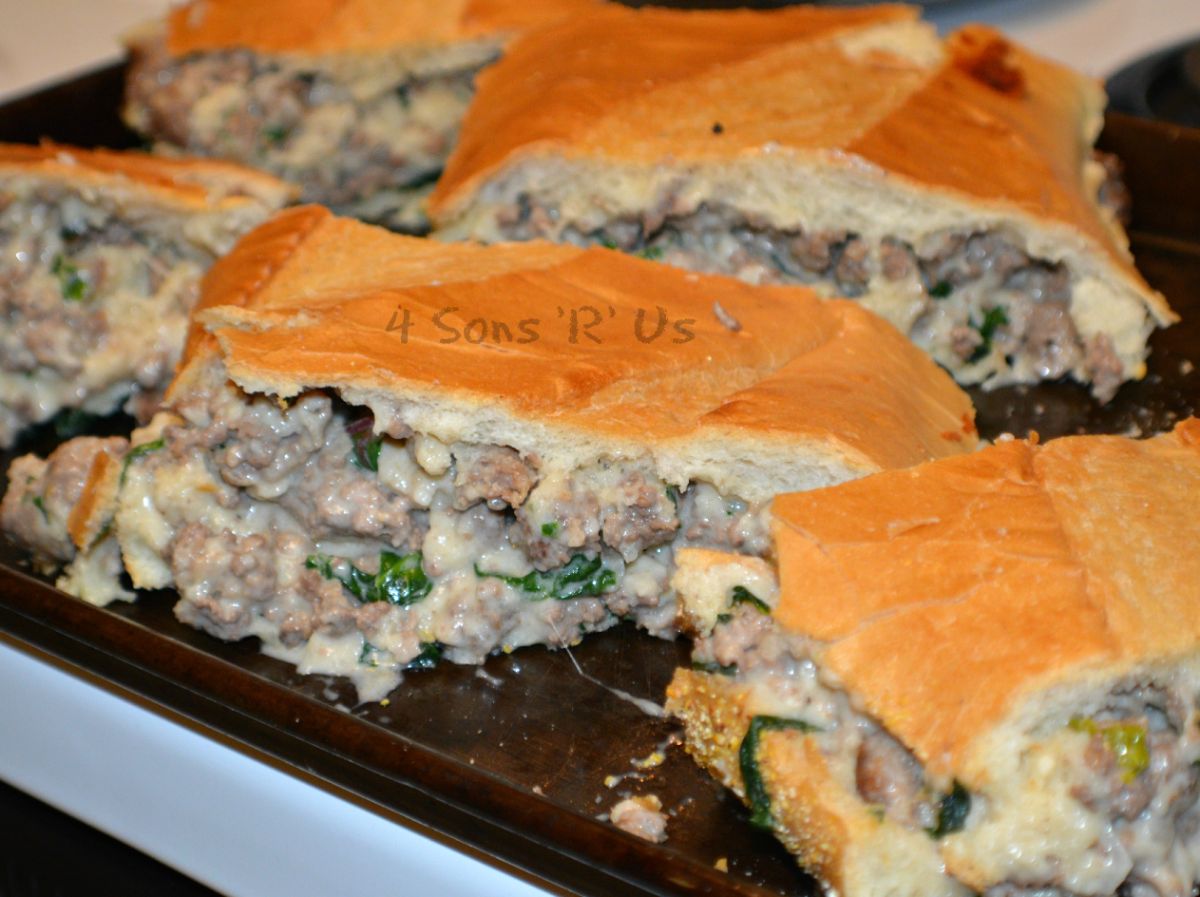 Juicy sausage alfredo stuffed french bread sandwiches on a tray.