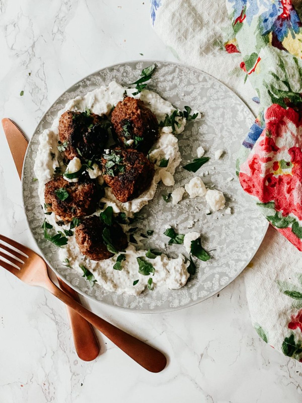Scrumptious greek bison meatballs on a gray plate.