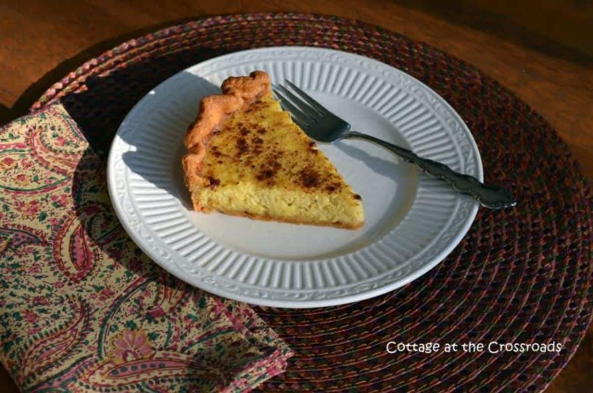 A piece of a spaghetti squash pie that's sweet! With a fork on a white plate.