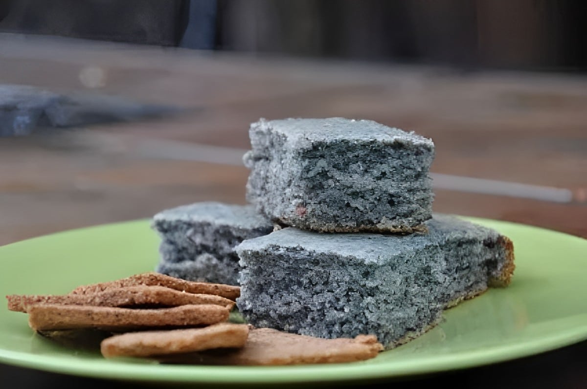 A bunch of blue corn almond flour cornbreads with crackers on a green plate.