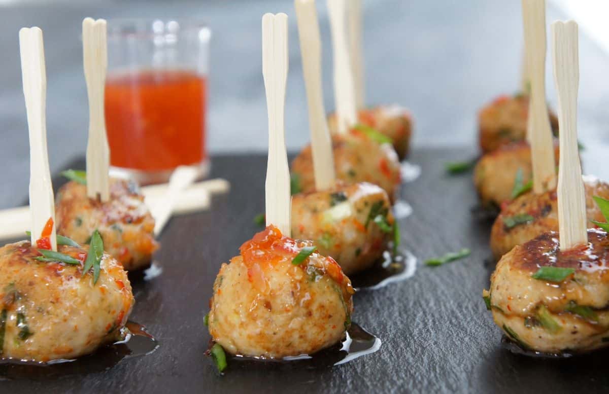 Delicious chicken meatballs on a black tray.