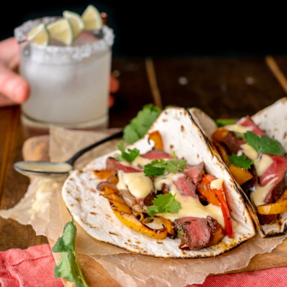 Fresh grilled elk steak fajitas on a wooden table.