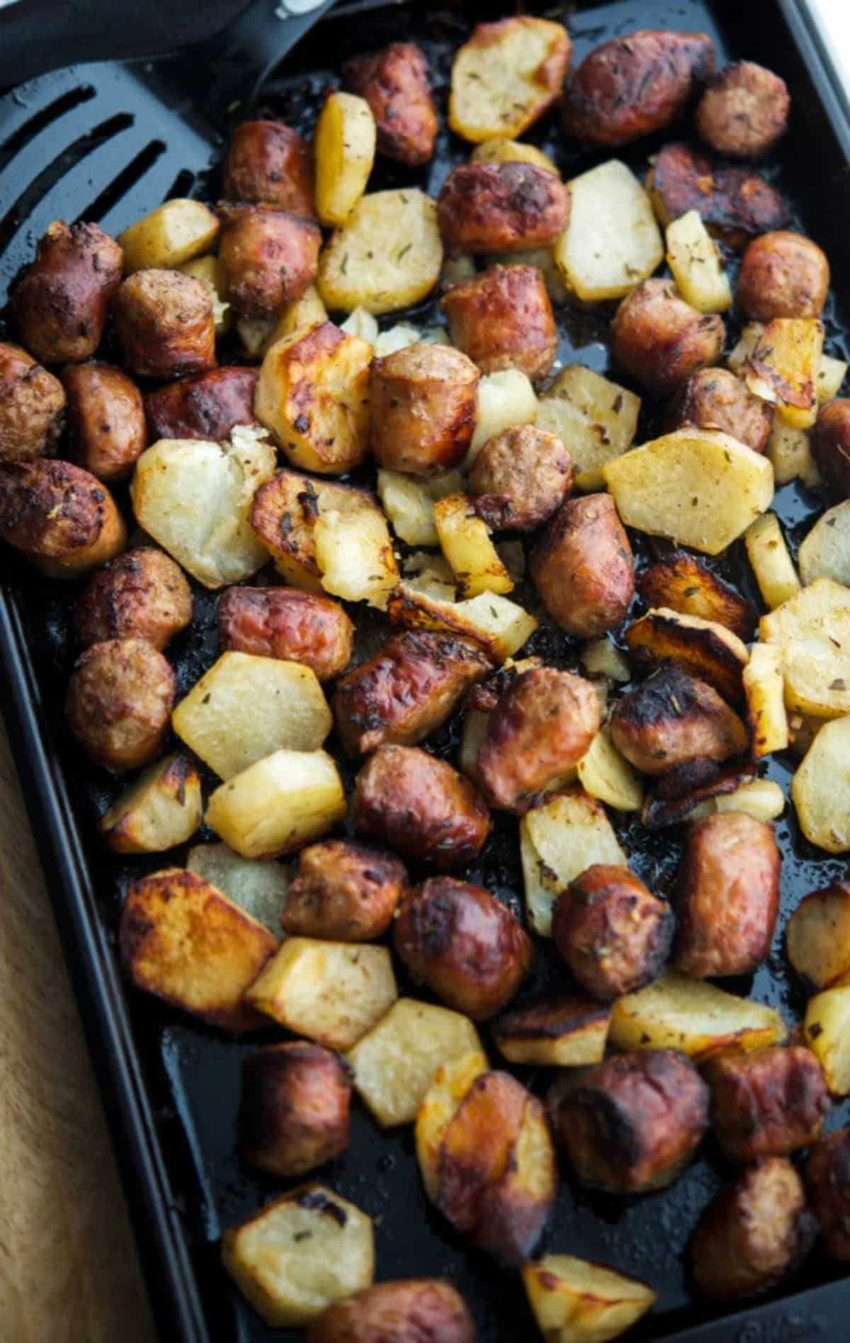 Healthy roasted italian sausage & potato bake on a tray.