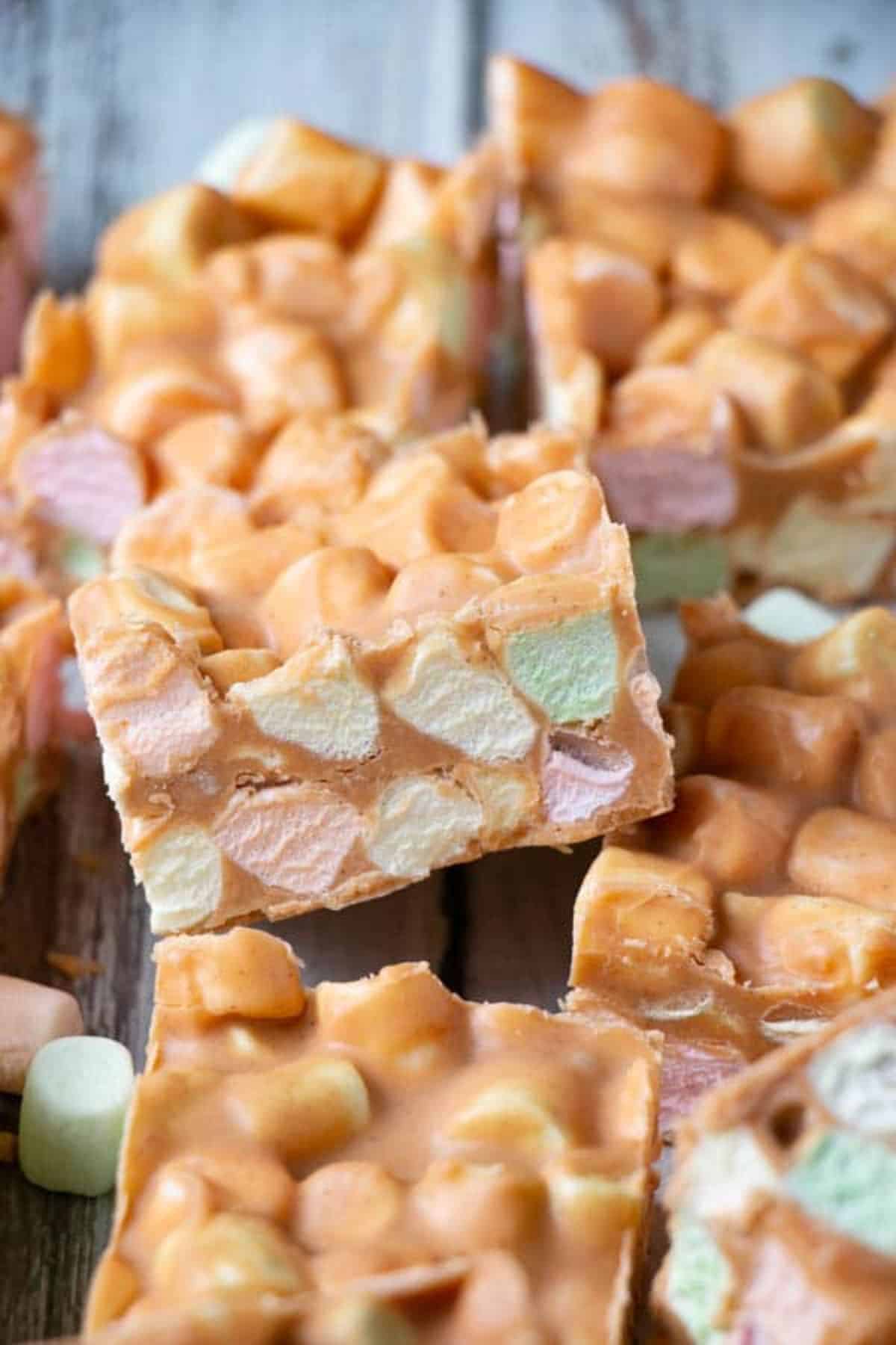 Flavorful butterscotch peanut butter marshmallow confetti squares on a wooden table.