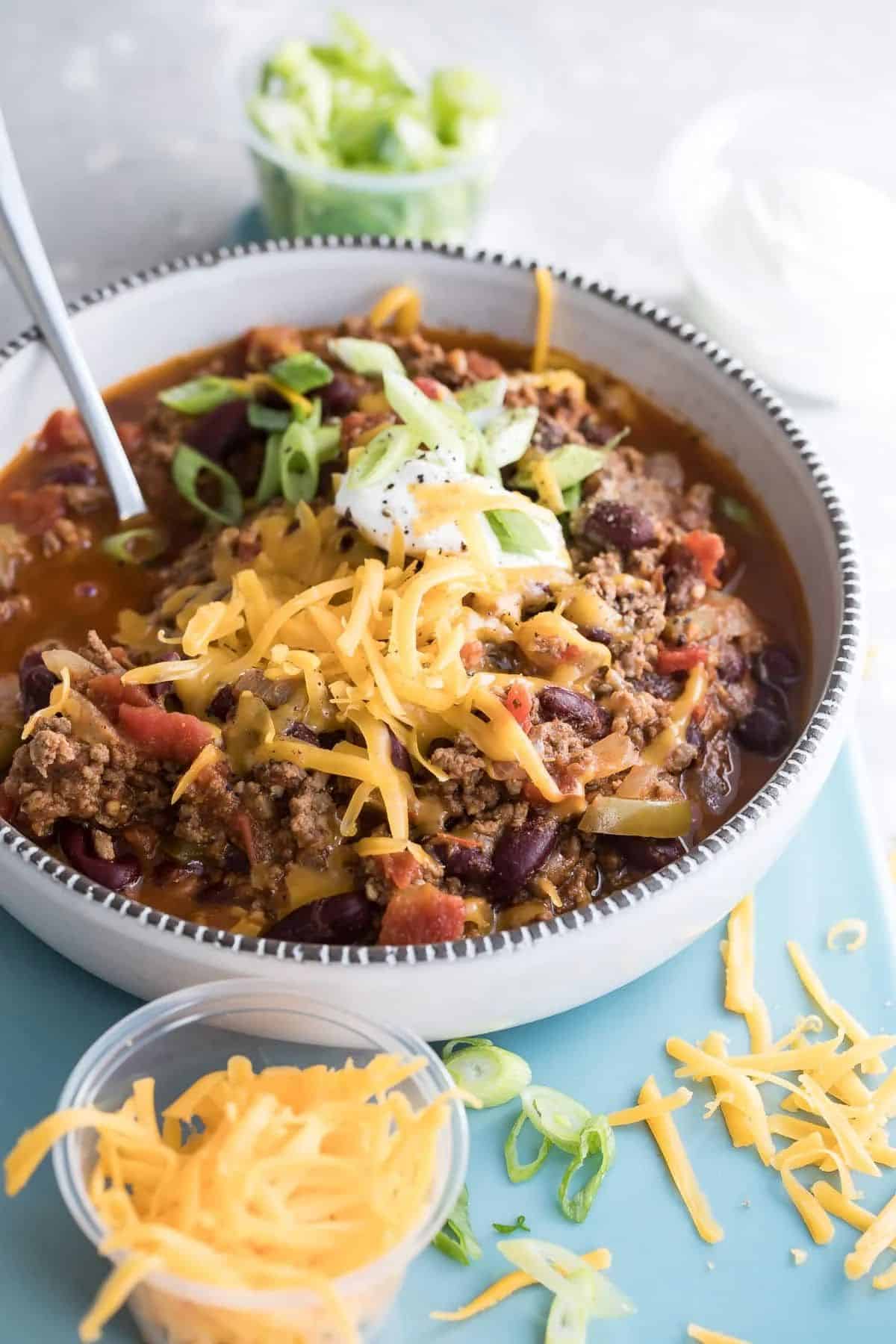 Tasteful venison chili in a bowl with a spoon.