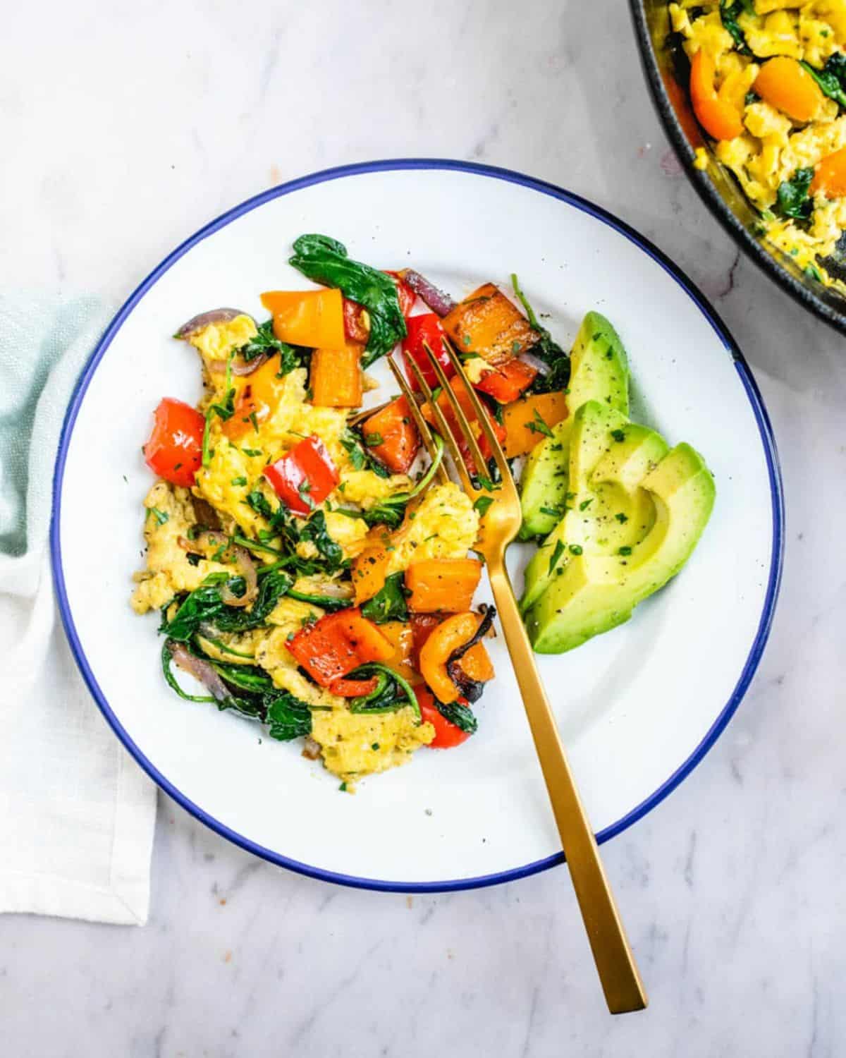 Healthy breakfast vegetable scramble on a palte with a fork.