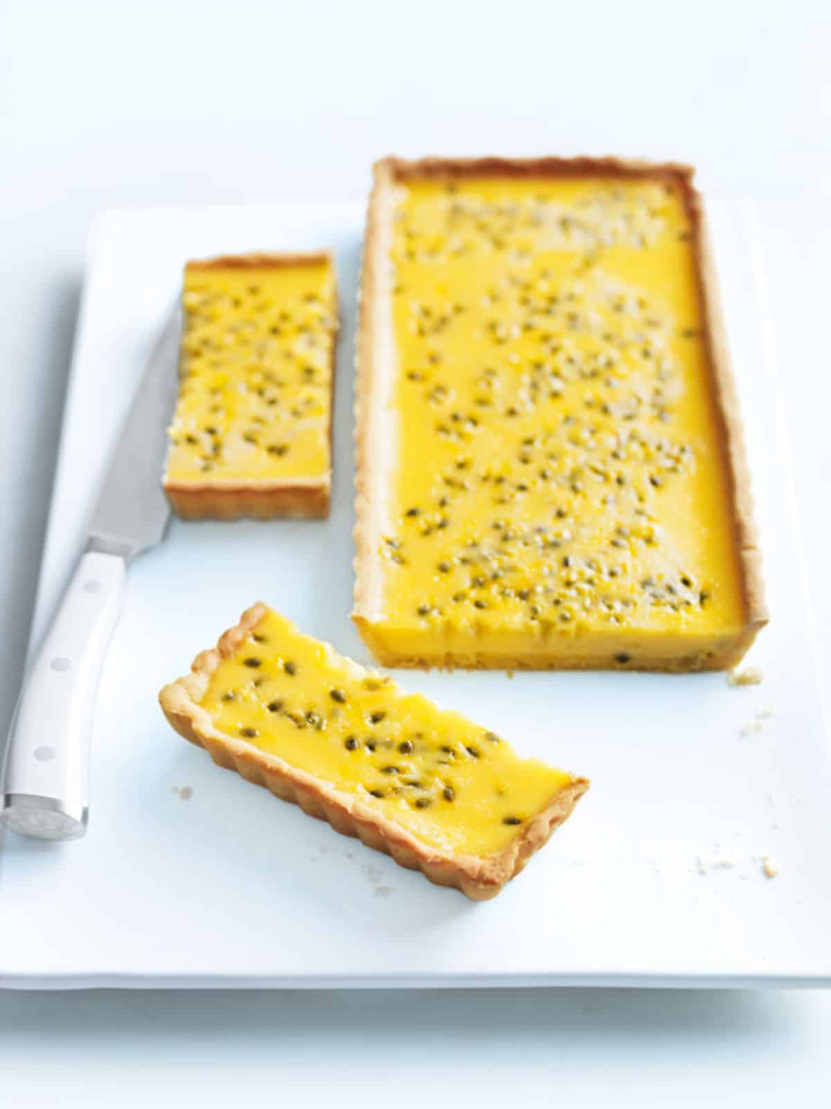 Scrumptious passion fruit tart on a white tray.